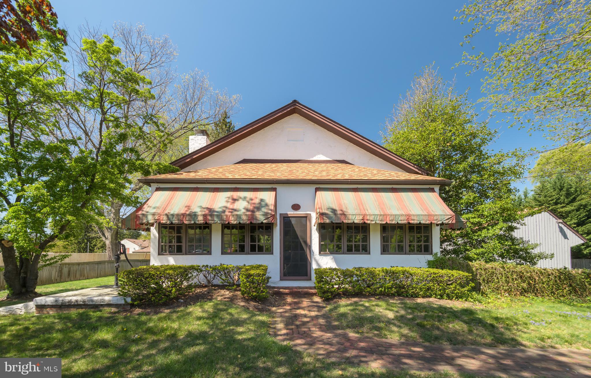 Welcome to 381 East Swedesford Road, a charming and historically significant single-family home in Tredyffrin Township. Built in 1871 as a township schoolhouse, this distinctive property has been thoughtfully converted into a one-bedroom residence that offers unparalleled Old World Charm and detailing. An extraordinary home where no detail has been overlooked. A three-season front porch with brick flooring sets the tone and leads into the grand living and dining area, highlighted by soaring ELEVEN foot high ceilings and a wood-burning fireplace with a colonial mantel and brick hearth. This is a versatile, open space. The owner’s bedroom features two walls of closet and windows with inside shutters and deep window sills. The eat-in kitchen offers knotty pine cabinetry and generous counter space. A full bathroom with a tiled shower is enhanced by a skylight that provides tremendous sun and light. A rear mudroom/vestibule connects directly to the oversized two-car garage and provides access to the finished lower level. The basement is a standout feature, showcasing exposed beams dating back over 150 years and a brick floor,  heated by under-floor copper hot water radiation, sourced from Philadelphia. This level also includes a spacious laundry/storage room and a separate utility room. Set on a level one-acre lot with a circular driveway, the property also includes the original schoolhouse outhouse, adding to its unique provenance. Architectural details such as deep windowsills, period hardware, and original fixtures further distinguish the home. Whether you choose to reimagine the interior, expand the footprint, or enjoy it as it stands, this is a rare opportunity to own a piece of local history. Located close to the King of Prussia Town Center, the Gateway Shopping Center, Valley Forge and Wilson Farm Parks and the shops, restaurants, and train lines of the Main Line. All of this within the top-ranked Tredyffrin-Easttown School District. This is it. This is the one. Welcome home!