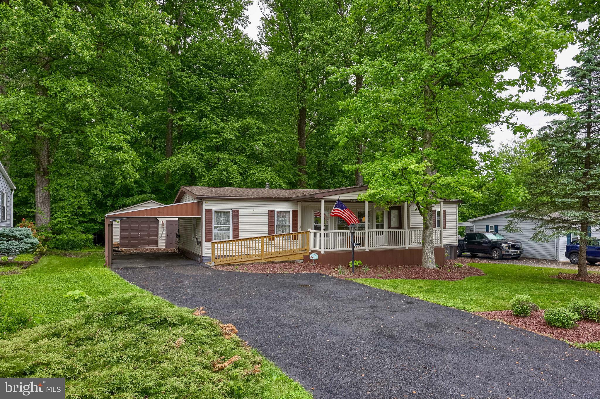 Welcome to 12 Poplar Drive! This home is located in the desirable Gretna Springs 55+ Community! With 2 bedrooms, 2 full bathrooms, and over 1,250 sq ft of living space, this home has an open floor plan that flows from the living room into the kitchen and dining area. The primary bedroom features an attached full bathroom with a step-in shower and a walk-in closet. The second bedroom offers a large closet, with another full bathroom just outside the door. Enjoy the outdoors on your large front porch or sitting on enjoying the wooded back yard.  The home is equipped with a Generac generator, giving you peace of mind knowing you'll stay comfortable, regardless of the weather. The oversized 1 car garage is great for extra storage or to be used as a workshop. It’s centrally located off Route 72, just minutes from the PA Turnpike and Route 322. Lot rent includes water, sewer, trash, and access to the community center. Don’t miss out—schedule your showing today!
