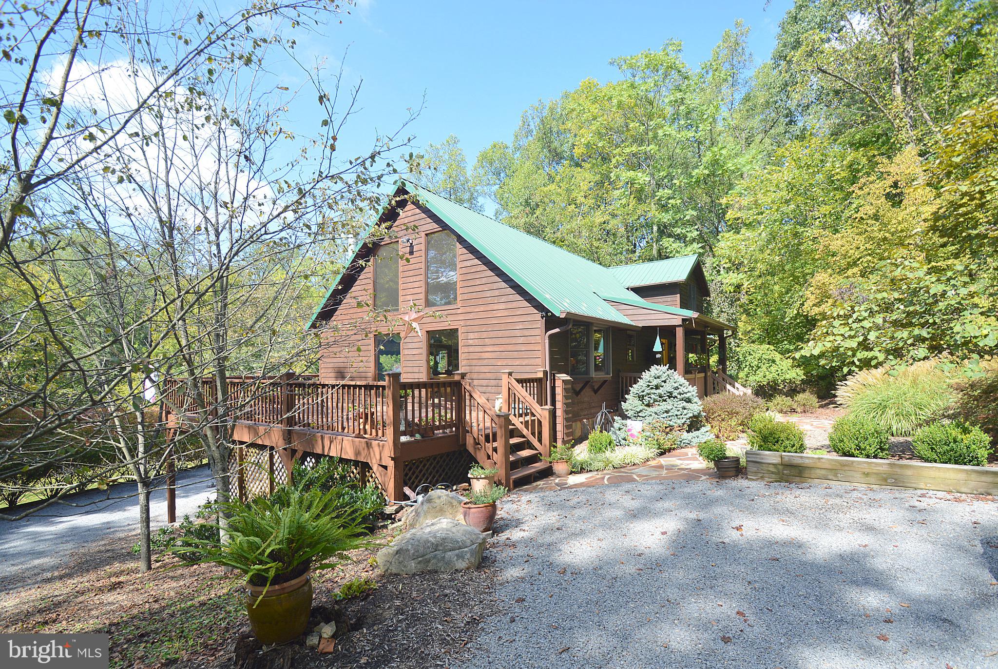 Remarkable home on 10 Plus acres in a park-like setting.  Cedar sided with a metal roof and large deck, storage shed, screen porches, and basement level garage.  Hardwood floors, gas fireplace, chalet windows, are nice interior features.  Upstairs features a master bedroom, full bath, and half bath.  Plenty of space on main level with lots of natural light, and a large kitchen. Lower level features and office, screen porch, and garage access.  Property is about 3 miles to Berkeley Springs and in a good central location.