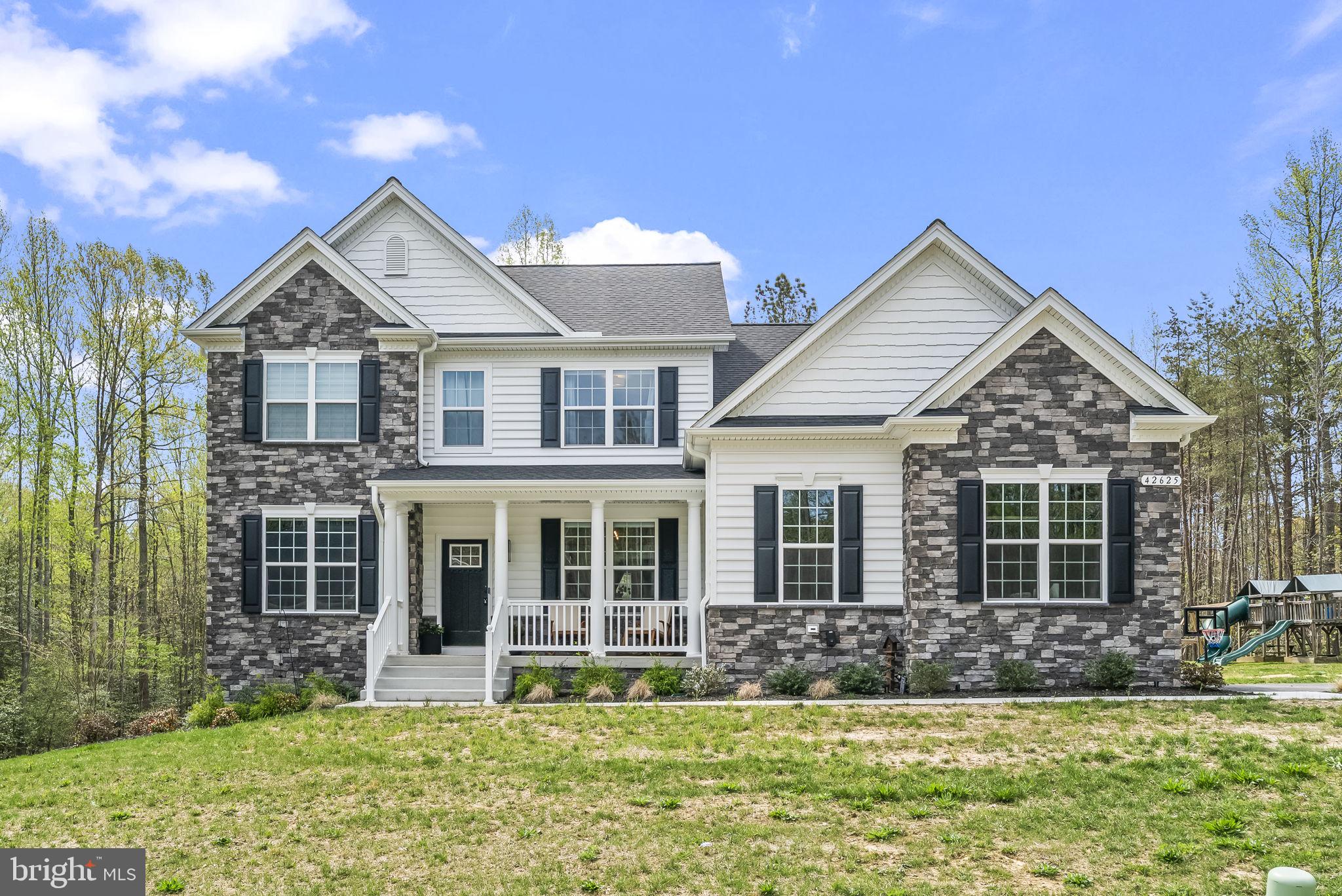 PRICE REDUCED!!! Welcome to refined living in this exceptional QBHI Fairfax model, perfectly situated on nearly two private acres and just 16 months young. Located in the highly sought-after Broyhill community of Leonardtown, this beautifully crafted home blends luxury, comfort, and thoughtful design at every turn. From the moment you arrive, you’ll appreciate the expansive, mostly flat yard—ideal for outdoor enjoyment—with a pool, swing set, and storage shed already in place. The attached two-car garage is equipped with a Tesla charger, adding modern convenience to this stunning property. Step inside to discover a truly gourmet kitchen that will impress even the most discerning chef. Featuring striking white quartz countertops with elegant gray veining, custom tan wood cabinetry with burnished copper finishes, high-end multi-paneled Samsung appliances, and a charming farmhouse sink, this space is both functional and beautiful. The adjoining breakfast nook sits within a generous 4-foot bump-out morning room, filling the space with natural light.The family room is a showstopper with its cozy gas fireplace and dramatic floor-to-ceiling stone façade—perfect for gathering or relaxing evenings at home. The main level also offers a formal dining room, an expansive side-by-side office, a convenient drop zone with built-in storage leading to the garage, a private bedroom with a full attached bath, and an additional powder room for guests. Downstairs, the fully finished basement expands your living space with a large recreation area perfect for movie nights or entertaining, along with an additional bedroom and full bath.Upstairs, you’ll find four generously sized bedrooms, including a luxurious primary suite complete with a sitting area, dual walk-in closets, and a spa-inspired bath featuring dual sinks with ample cabinetry, a soaking tub, and a spacious 6' x 6' deluxe shower. Three additional bedrooms share a well-appointed hall bath with dual sinks, and the conveniently located upper-level laundry room makes everyday living effortless. Nestled in a community known for its curated selection of craftsman-style homes and spacious lots, Broyhill offers both privacy and charm. Enjoy peaceful surroundings while just minutes from downtown Leonardtown’s shopping and dining, and from nearby Dorsey Park for outdoor recreation. This is the one you’ve been waiting for—schedule your private tour today!