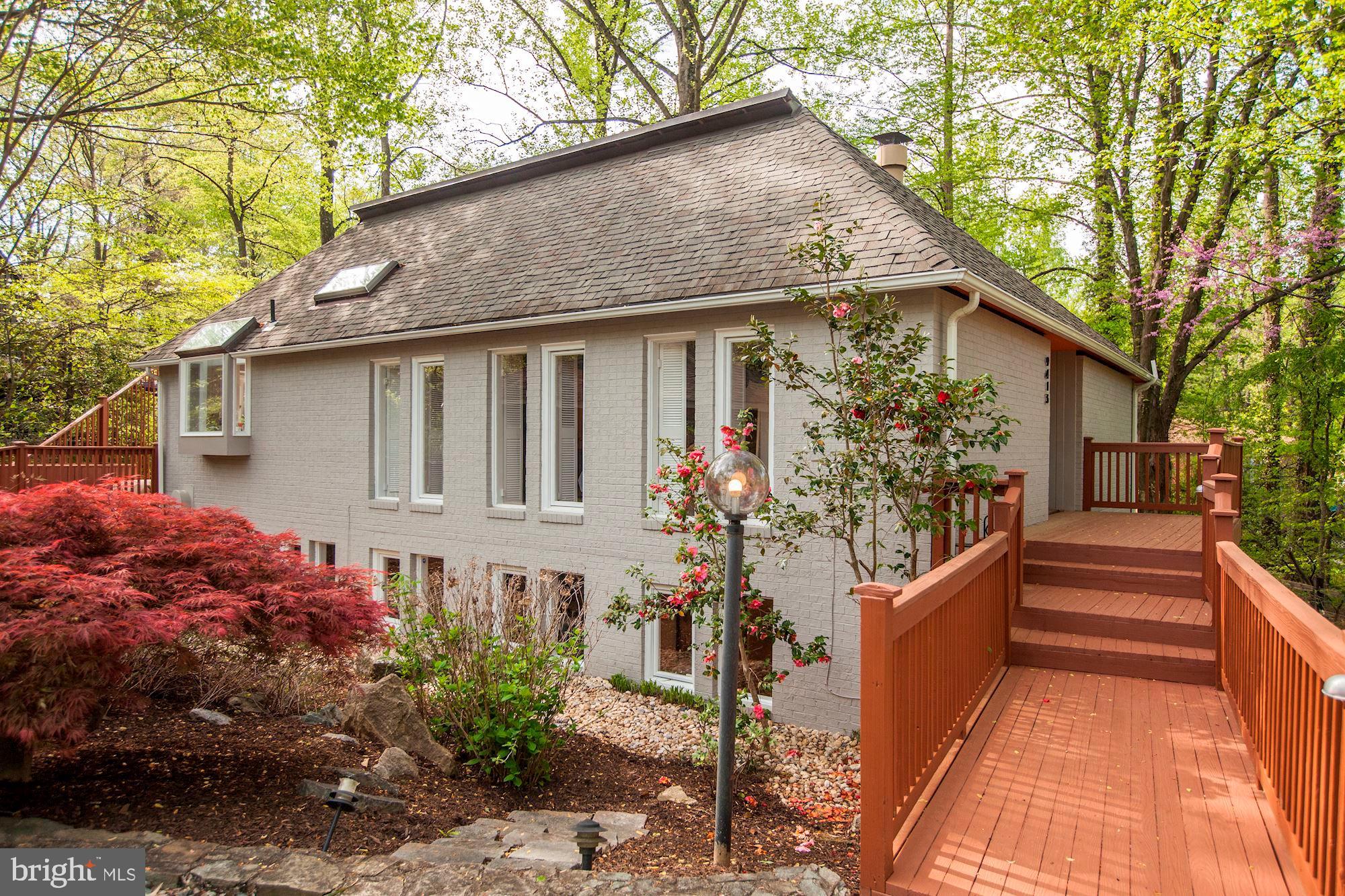 Spectacular contemporary nestled in the woods. Main level is light filled and has an open and airy floor plan. Featuring hardwood floors, skylights,  high vaulted ceilings, recessed lighting, built-in cabinetry and the contemporary layout gives this home tremendous character.  All white kitchen features corian counter tops, tile back splash, vaulted ceilings, plenty of cabinet space and a view of the woods.   Main level master bedroom features hard wood floors, vaulted ceilings, large walk-in closet, luxury master bath with jetted tub and shower stall that is sunlit with a skylight. Backyard features a 2 tiered deck, and the partially wooded lot provides plenty of privacy. Three of the bedrooms on the lower level accompanied by a large family room.