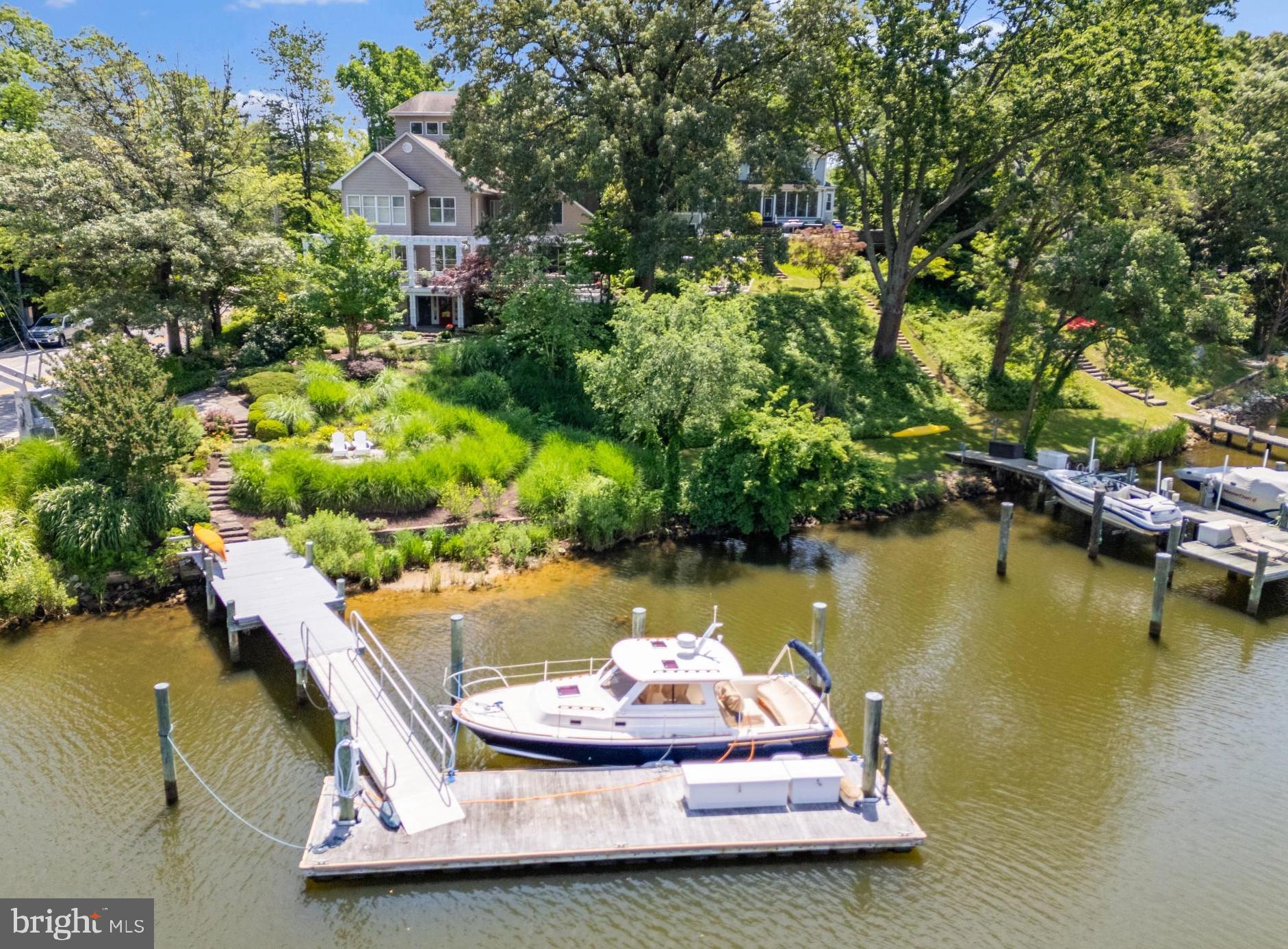 Coveted West Annapolis Waterfront property with deep water floating dock! Recently updated with fresh paint, refinished floors and new carpeting throughout. Experience elegance and grace in this stunning 4 story home that is sure to captivate. The contemporary architecture and voluminous spaces mixed with traditional finishes and floor plan creates a wonderful combination. Expertly designed and built additions include the glass enclosed lanai with elevator and guest room above in 2006, Living room, 2 car garage and bird's nest with balcony completed in 2009, gourmet Kitchen was expanded and beautifully updated in 2015. Upon entry, the soaring foyer is awe-inspiring and the elegant living room, with built-in bar, sets the tone.  With 3 custom bars and multiple gathering areas, this home is perfect for entertaining.  The gourmet kitchen is a chef's dream, featuring a large island and top-of-the-line finishes and breakfast nook, which flows seamlessly into the spacious family room with walls of windows overlooking Weems Creek. The adjacent library/den boasts mahogany built-ins and flooring, gas fireplace and views; a perfect place to curl up with a book. This home offers three ensuite bedrooms for ultimate comfort and privacy. The master bedroom is a sanctuary with a vaulted ceiling, custom built-ins, enormous walk in closet for 2 and the best views in the house.  Wake up every morning and enjoy the activity on the sparkling waters of the creek and the Severn River. The spacious guest room suite with glass breezeway from the main house boasts an elevator directly into the room, creating a truly private oasis for guests and family. This floor also includes an additional bedroom or theater room with adjacent hall bath; providing flexible living options. The fourth floor features a unique bird's nest with elevator access and a wrap-around deck offering panoramic views of Weems Creek and the Severn River. With three elevators throughout the house, accessibility to all four levels is effortless. The exquisite sunroom with folding glass doors epitomizes indoor/outdoor living. Simply open 2 sides of the room to the outdoors and let the party flow onto the sprawling rear deck. The wrap-around IPE deck and multiple level seating areas are ideal for taking in the incredible views from every vista. The lush landscaping and stone stairs lead to the water's edge and the private pier with deep-water floating dock with multiple slips can accommodate a 50ft yacht. Be sure to not miss the stone patio on the way down; ideal for relaxing as the sun sets. This property truly captures the essence of waterfront living by blending luxury and comfort in an unparalleled setting. Welcome Home!