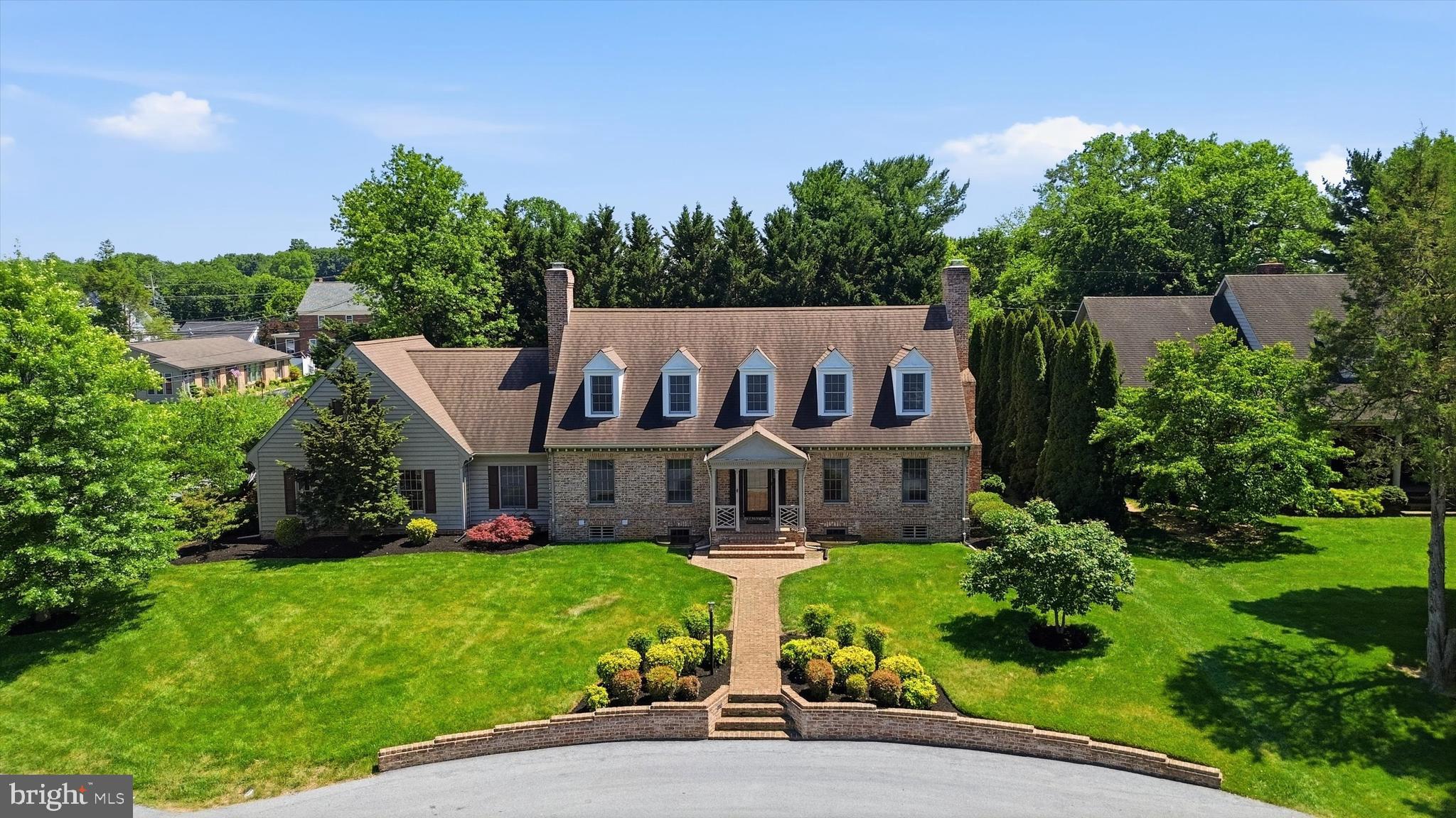 EXCEPTIONAL HOME WITH PRIVATE GUEST HOUSE! This remarkable property showcases timeless craftsmanship, luxury finishes, and outstanding curb appeal with classic Cushwa brick construction and beautifully manicured grounds.

The main residence features hardwood flooring throughout and a thoughtfully designed floor plan ideal for both everyday living and entertaining. The inviting living room is highlighted by a wood-burning fireplace, while the formal dining room provides an elegant setting for gatherings. The gourmet custom kitchen is appointed with maple cabinetry, quartz countertops, Carrera marble backsplash, and a premium 6-burner Fulgor Milano gas range. Open to the kitchen, the spacious family room offers a cozy gas fireplace, convenient half bath, and adjoining bar/recreation area.

The upper level features a spacious primary suite with an enclosed tiled bath, soaking tub, dual vanities, and ample closet space. Three additional bedrooms and 2 full baths complete the level.

The partially finished lower level expands the living space with a recreation room, hot tub, sauna, full bath, and abundant storage.

Adding versatility and value, the attached guest house provides private accommodations complete with a living room, kitchen, bedroom, full bath, and laundry—ideal for extended family, guests, or multi-generational living.

Outdoor living is equally impressive, featuring a brick patio, pergola, and beautifully landscaped gardens that create a serene setting for relaxation and entertaining. This exceptional property offers a rare combination of quality construction, thoughtful design, and flexible living spaces.