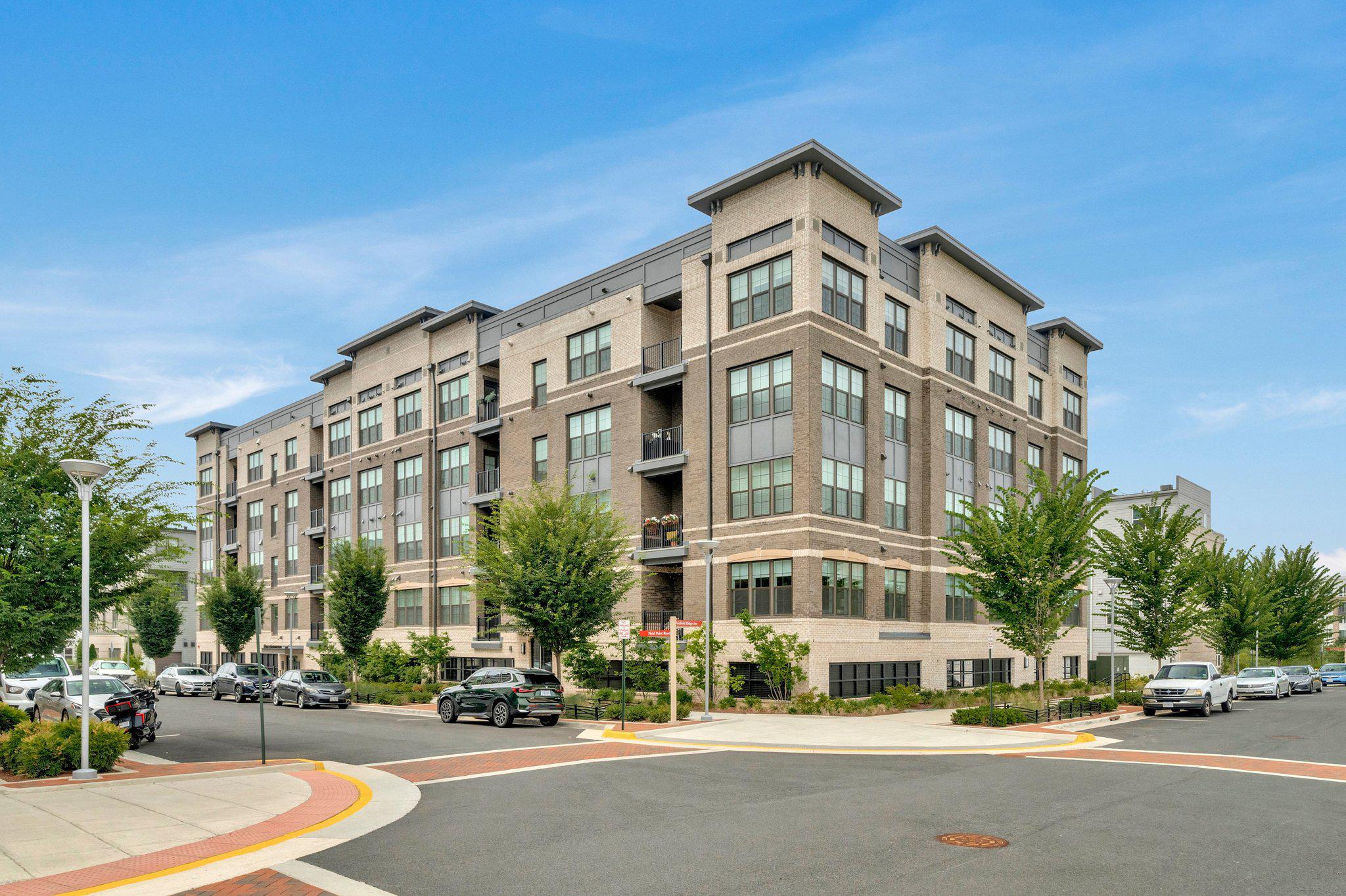 Welcome to this like-new, contemporary 2-bedroom condominium with a separate den/office, offering effortless single-level living in a highly convenient Herndon location. Ideally positioned with south and east exposures, this bright and inviting home is filled with natural light throughout the day.
The gourmet kitchen—featuring the builder’s premium kitchen upgrade package—serves as the heart of the home, showcasing premium quartz countertops, a large center island with seating, upgraded stainless steel appliances, a new French door refrigerator, and a stainless-steel hood vented to the exterior—a sought-after feature for serious cooking enthusiasts. The clean, modern design flows seamlessly into the main living space. Custom window treatments are found throughout, including remote-controlled shades in the living room for added comfort and convenience.
Located one level above street level with parking beneath the building, this thoughtfully designed unit features an open-concept layout connecting the kitchen, dining, and living areas—perfect for both everyday living and entertaining.
A dedicated den/office provides ideal flexibility for remote work, study, or a quiet retreat—an increasingly valuable bonus space in today’s lifestyle.
The spacious primary suite offers a generous walk-in closet and a well-appointed bath with dual vanities and a glass-enclosed shower featuring dual shower heads. A secondary bedroom and full bath provide comfortable accommodations for guests or additional household needs.
Additional highlights include wide-plank flooring, a dedicated laundry room, covered balcony, ample storage, one reserved garage space (#2), and one outdoor parking space.
Residents enjoy a full suite of community amenities including walking paths, courts, playgrounds, and nearby open space, along with a direct pedestrian connection to the Innovation Center Metro station and easy access to Reston Town Center, Washington Dulles International Airport, shopping, and dining.
This move-in ready home delivers a seamless blend of comfort, functionality, and modern design in one of Northern Virginia’s most connected communities.