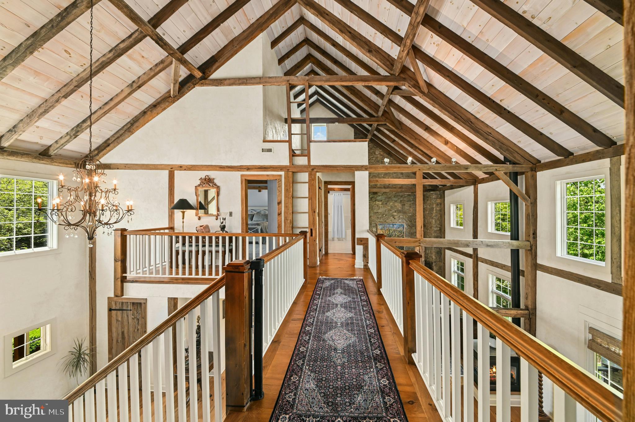 This amazing property is just steps away from the renowned Saucon Valley Country Club. Welcome to marvelous architectural features at every turn. This Saucon Valley home’s extraordinary character evolved from a legacy barn restored into a unique residence that boasts the best of old and new … combining space, light and imagination.
Inside, warm wood flooring, custom doors and cabinetry, exposed posts and beams, cathedral ceilings and stunning window placement set the mood for a perfect retreat that redefines the meaning of barn conversion. The main floor is boldly open and yet delivers an intimate warmth with a fabulous, white, gourmet kitchen. The flow between the spacious rooms is inviting and free. A first floor master bedroom suite, with fabulous bath, is a romantic oasis. Two additional 2nd floor bedrooms and an office are distinctive, with vaulted, beamed ceilings and dramatic window placements. Finally, the expansive
lower level provides a family room, guest room and full bath and doors to the outside in every room.
A covered deck and covered patio with fireplace are surrounded by magnificent gardens that bloom all year round. This magically private property is just minutes from the Promenade shops, convenient to I-78 and under 90 minutes to NYC. Relax amidst your beautiful gardens or play a round of golf and dine at the world class Saucon Valley Country Club.