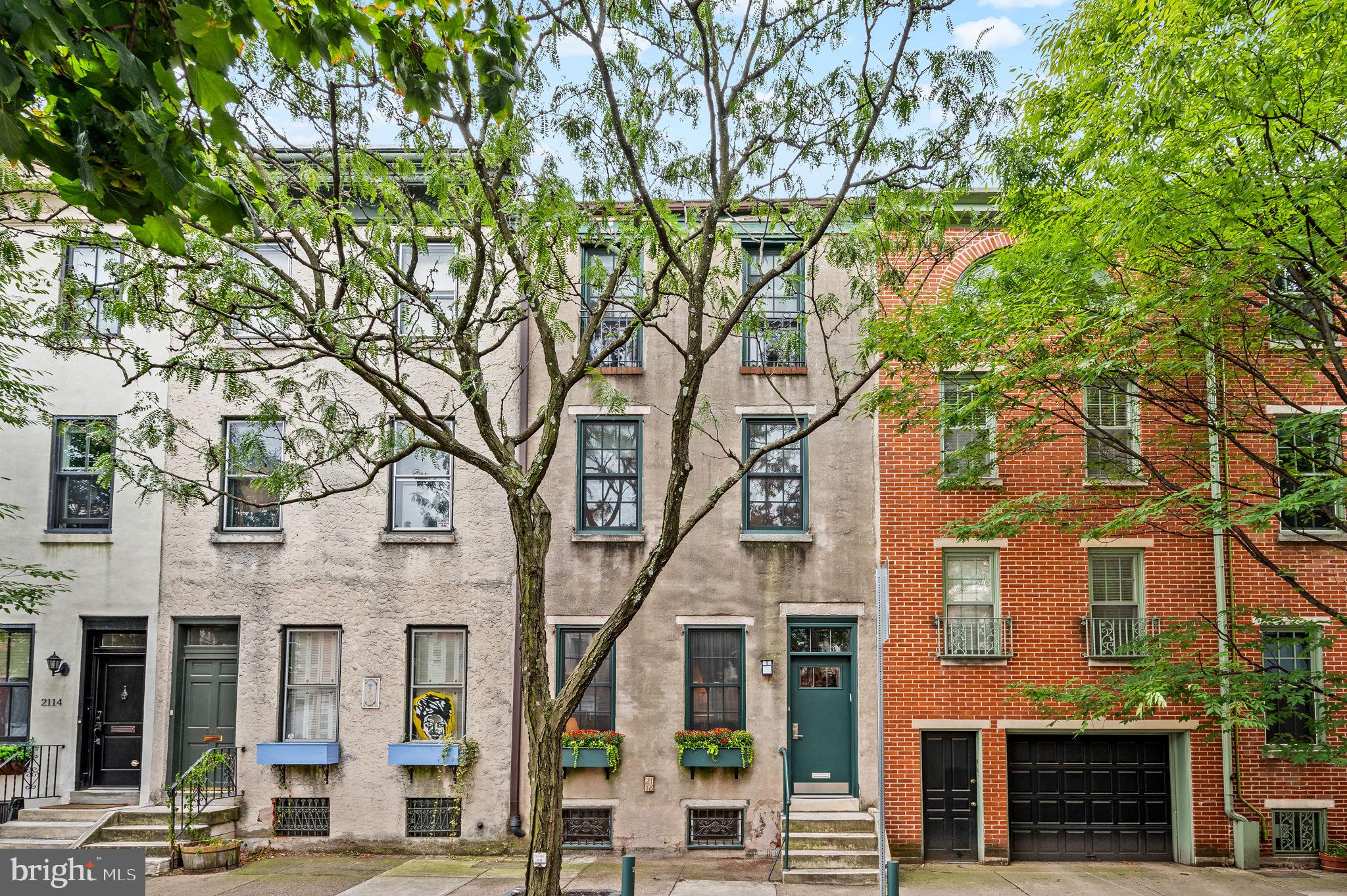 Charming on Cherry! This 4 bedroom, 2.5 bath home with parking and 3 outdoor spaces, is located in the vibrant Logan Square neighborhood, conveniently positioned between the Art Museum and Rittenhouse Square. This stunner—built in 1851—combines classic charm with modern updates, offering a blend of historical character and contemporary living. Step into the light-filled vestibule and feel the warmth of the original, random-width pine flooring.  The spacious living room boasts high ceilings, a striking fireplace with a Venetian plaster finish, a hidden dry bar perfect for entertaining, and custom built ins. The home was extended to include a hidden gem of the outside alley coming in, with a powder room and two charming vignettes with stone walls and skylights that flood the space with natural light. The separate dining room showcases masterful craftsmanship with custom woodwork, including shelving, wine racks, and additional storage. A few steps down, you’ll find a Chef's kitchen with radiant floors, equipped with a Wolf 48-inch dual fuel range. The range includes one and a half ovens, 4 burners, an infrared charbroiler, and an infrared griddle. . The oversized stainless steel farm sink offers a lovely view of the picturesque bricked patio, complete with a trellis, which discreetly conceals an outdoor dining area, a single pink dogwood tree, and the 1-car parking area off Appletree Street. Take the elegant original central winding staircase to the second floor, where you'll find a spacious rear bedroom with its own private deck. This level also includes a hall laundry room with a hidden ironing board, a laundry chute, and a shared hall bath featuring dual sinks, medicine cabinets, and ample storage. The front bedroom offers fantastic closet space and built-in shelving. The top floor features a rear bedroom with an exposed brick accent wall and a deck showcasing impressive city views. The front bedroom, accessed through original double glass doors, leads to the Primary Bedroom. This room boasts vaulted ceilings with original beams, an accent brick wall, and a full wall of California Closets. The renovated  en-suite bath includes dual sinks and an oversized tiled shower with dual shower heads, radiant floors and a skylight. The space also features a mini-split for efficient air conditioning and bonus hidden storage accessible through a pull down ladder to a carpeted attic. Not to be missed in the lower level, is the partially finished basement with extra fridge and sink, as well as a cedar closet for seasonal clothing! This property is steps away from Coxe Park, Trader Joe's, Giant, Wholefoods, The Franklin Institute, Rittenhouse Square, The Art Museum, and the Swann Memorial Fountain. It also offers close and easy access to 30th Street Station and both the Vine Street and Schuylkill Expressways.
