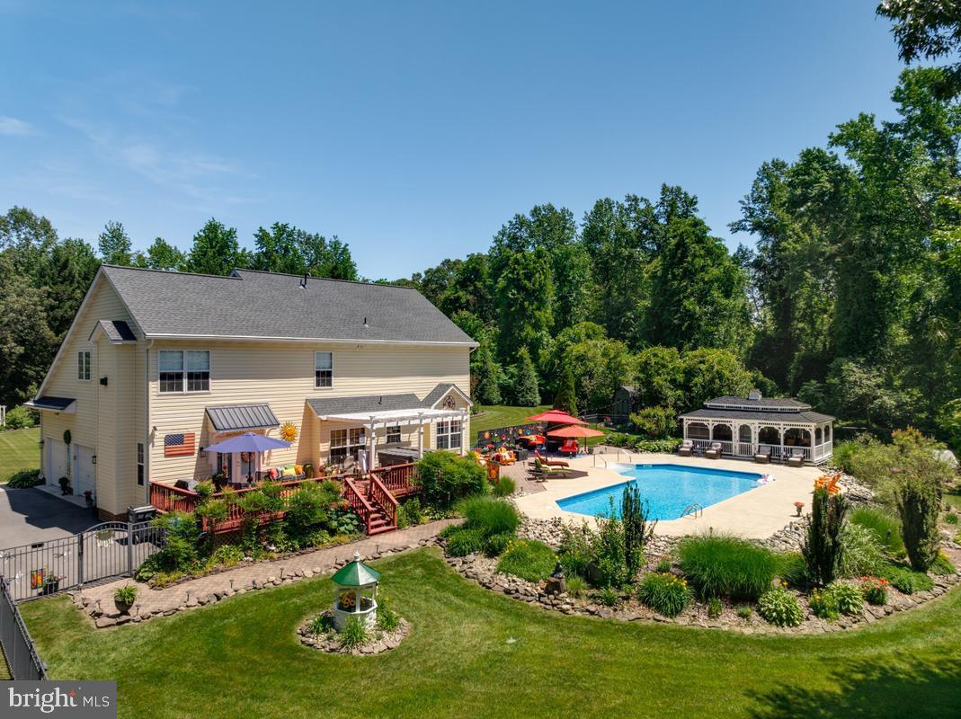 OPEN HOUSE SUNDAY JUNE 28TH 12 NOON - 2 PM - ALL ARE WELCOME - WE WILL HONOR YOUR AGENTS BUSINESS CARD IF THEY ARE UNABLE TO ATTEND THE OPEN HOUSE WITH YOU ! Welcome to this beautifully maintained custom-built home that sits on 3.41 private wooded acres offering 4 bedrooms, 3.5 baths, and exceptional indoor and outdoor living spaces. The main level features 9-foot ceilings, a dramatic two-story open foyer, private office/den, formal dining room with crown and chair molding, convenient half bath, and a spacious family room located just off the kitchen.

The kitchen is designed for both everyday living and entertaining, featuring 42-inch cabinets, granite countertops, cooktop, double wall oven, tile backsplash, center island, and dual pantries. Upstairs you will find 4 bedrooms and 2 full baths, including a generous owner’s suite with fireplace, his-and-hers closets, and a luxury bath with soaking tub.

The fully finished walk-up basement expands the living space with a gym/exercise room, custom built-in entertainment center, wet bar, full bath, and large recreation area with access to the backyard and pool area.

Outdoor living is a true highlight with a hot tub on the deck with pergola, 20x40 heated saltwater pool, 14x26 gazebo, , fenced backyard, lawn irrigation system, outdoor speaker system, two storage sheds, and extensive landscaping. Additional features include reverse osmosis water system, Culligan water treatment system, gutter covers, propane heat system, updated lighting, newer flooring, exterior doors, repaved driveway, and newer roof.

This home offers the perfect combination of space, comfort, updates, and resort-style outdoor amenities — ideal for entertaining, relaxing, and everyday living.