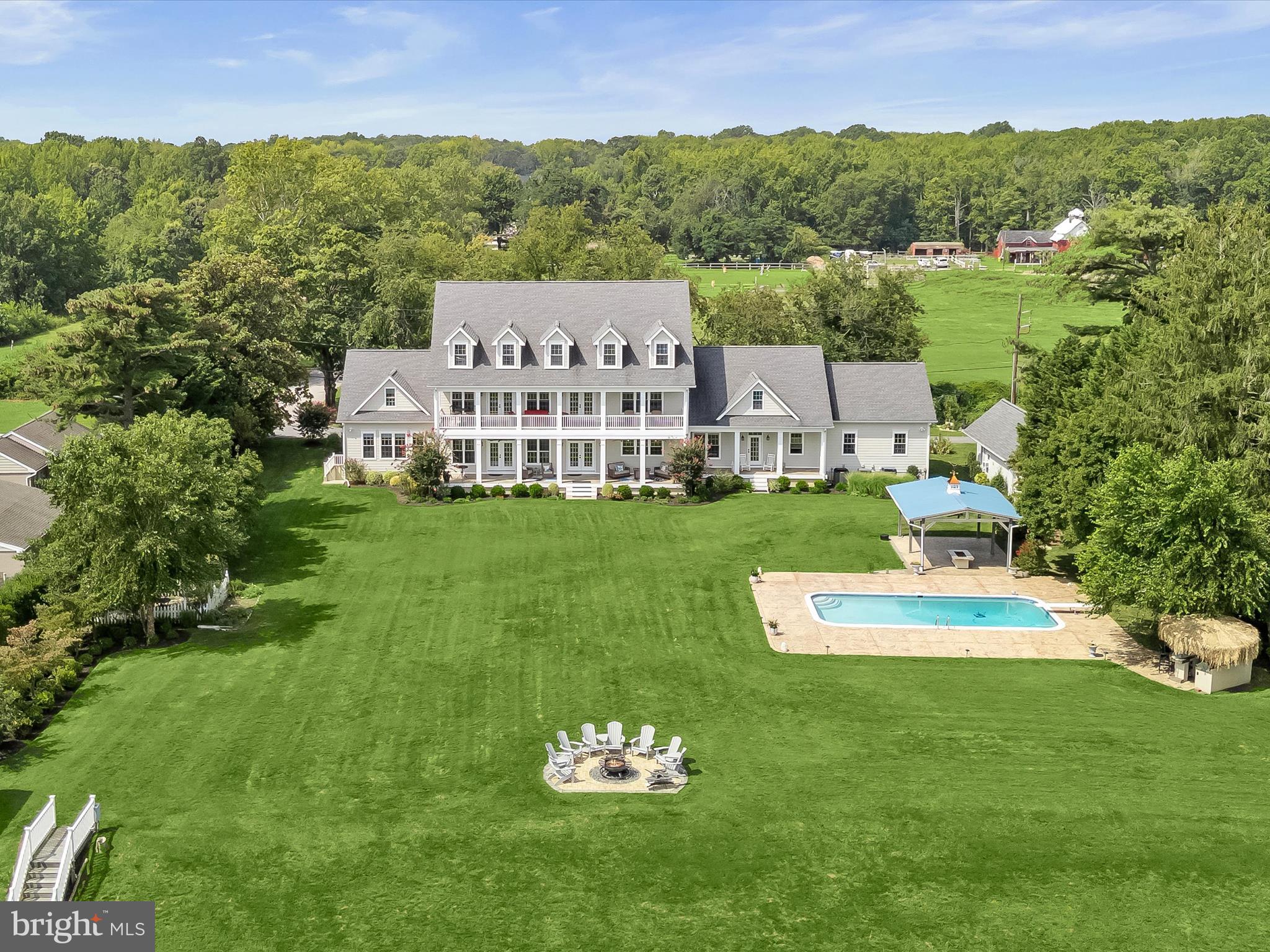 Welcome to 235 Bay Front Drive, a magnificent Chesapeake Bay waterfront property nestled at the end of a private lane with peaceful views from the front of the historic Flanigan horse farm. This stunning 1.3 waterfront property is a stone’s throw to Gibson Island. Just built in 2017, this substantial property boasts seven bedrooms and eight and one-half bathrooms.  
With amazing Bay views from the minute you open the door, ascend the front steps to a welcoming front porch, entering a large two-story foyer opening to a spacious living room. Enjoy the gourmet kitchen offering an expansive island with plenty of counter seating coupled with a kitchen table/nook and wet bar. The kitchen opens to a large dining area making for family relaxation and gracious entertainment.  Expansive Bay views abound from the kitchen and living room, both of which open to a fabulous open porch spanning the waterside house of the house. 
A primary bedroom with exquisite bath is on the main level, along with a second ensuite bedroom. An office with incredible Bay views, a half bath, laundry room and direct access to the three-car garage top off the main level.
Ascend the stairs to a fabulous entertainment room with a built-in bar, pool table area, and lounging space overlooking the Chesapeake Bay and opening to an expansive outdoor open porch with further exquisite Bay views and sunrises.  Four ensuite bedrooms complete the upper level.
Descend to the lower level to a game room, a den/cigar room, a stunning conditioned wine room, work out and gym area, a sweet reading nook, a secured area for storage, coupled with many additional storage spaces. 
An attractive detached guest cottage matching the house exterior includes a living room, kitchenette, bedroom, full bath, and washer and dryer. A three-car garage is connected to the house with plentiful parking in front of the house.
This property has it all, including lush landscaping, an in-ground salt swimming pool, a tiki bar, a covered entertainment area, and an outdoor wood-burning fire. The expansive yard overlooks the Bay with a sandy beach, and there is an approximate 190-foot pier with a covered electric lift and freshwater spigots and an additional side pier, all great for fishing, crabbing, and just plain relaxing and enjoyment of the Chesapeake Bay!