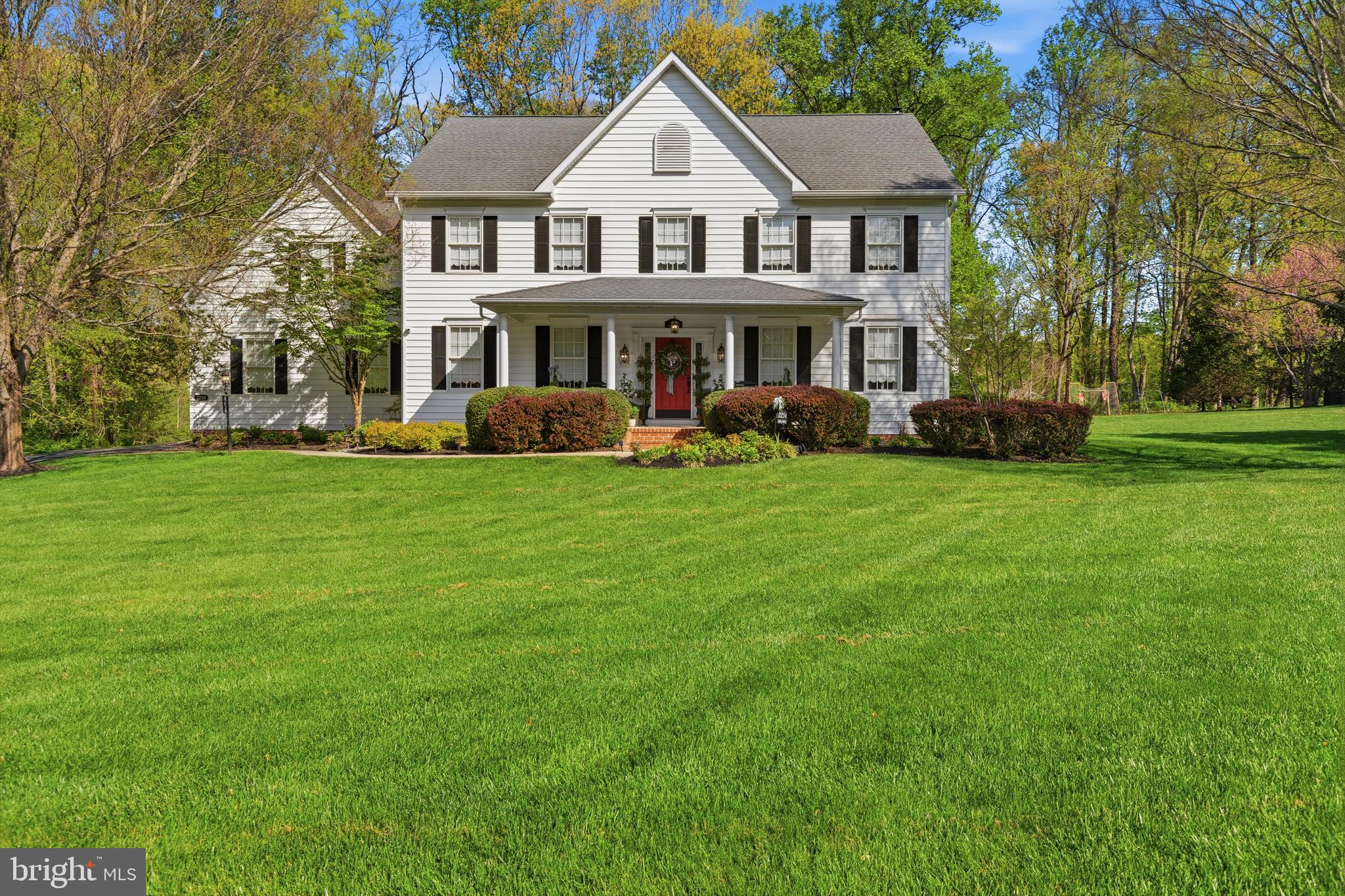 Set on over 3.5 picturesque acres in Forest Hill, this stunning single-family colonial makes a lasting impression with its stately columned front entry and timeless curb appeal. A welcoming foyer with hardwood floors sets the tone for the home’s elegant interior. To the right, the living room features crown molding and chair rail detailing. To the left, the formal dining room offers hardwood flooring along with crown molding and chair rail, creating an ideal space for gatherings and entertaining. The heart of the home is the beautifully appointed kitchen, complete with granite countertops, white cabinetry, stainless steel appliances, and a center island with built-in wine storage. A breakfast bar and sunny breakfast nook provide casual dining options, while the adjacent family room offers a fireplace and hardwood floors, creating a warm and inviting space. Upstairs, the spacious primary suite features a cathedral ceiling, plush carpeting, a striking chandelier, and a large walk-in closet. The en-suite bath includes a double vanity and a walk-in shower. Four additional bedrooms offer a mix of carpet and hardwood flooring, along with ample closet space, and share a well-appointed hall bath with a tub/shower combination. The fully finished lower level expands the living space with a large, carpeted recreation room featuring recessed lighting, as well as dedicated exercise and play rooms to suit a variety of needs. Additional highlights include a garage equipped with an electric car charger and energy-efficient geothermal heating. The basement has been painted beige after the photos were taken. Step outside to enjoy the beautifully designed outdoor living areas, including a covered stone porch with a ceiling fan, extensive hardscaping with a fire pit, a stone patio—perfect for relaxing or entertaining, and invisible fencing. The expansive, tree-lined property offers a peaceful, private setting with plenty of open green space, making it an exceptional retreat that blends luxury, comfort, and nature! Seller is offering a $10,000 credit toward flooring and/or painting.