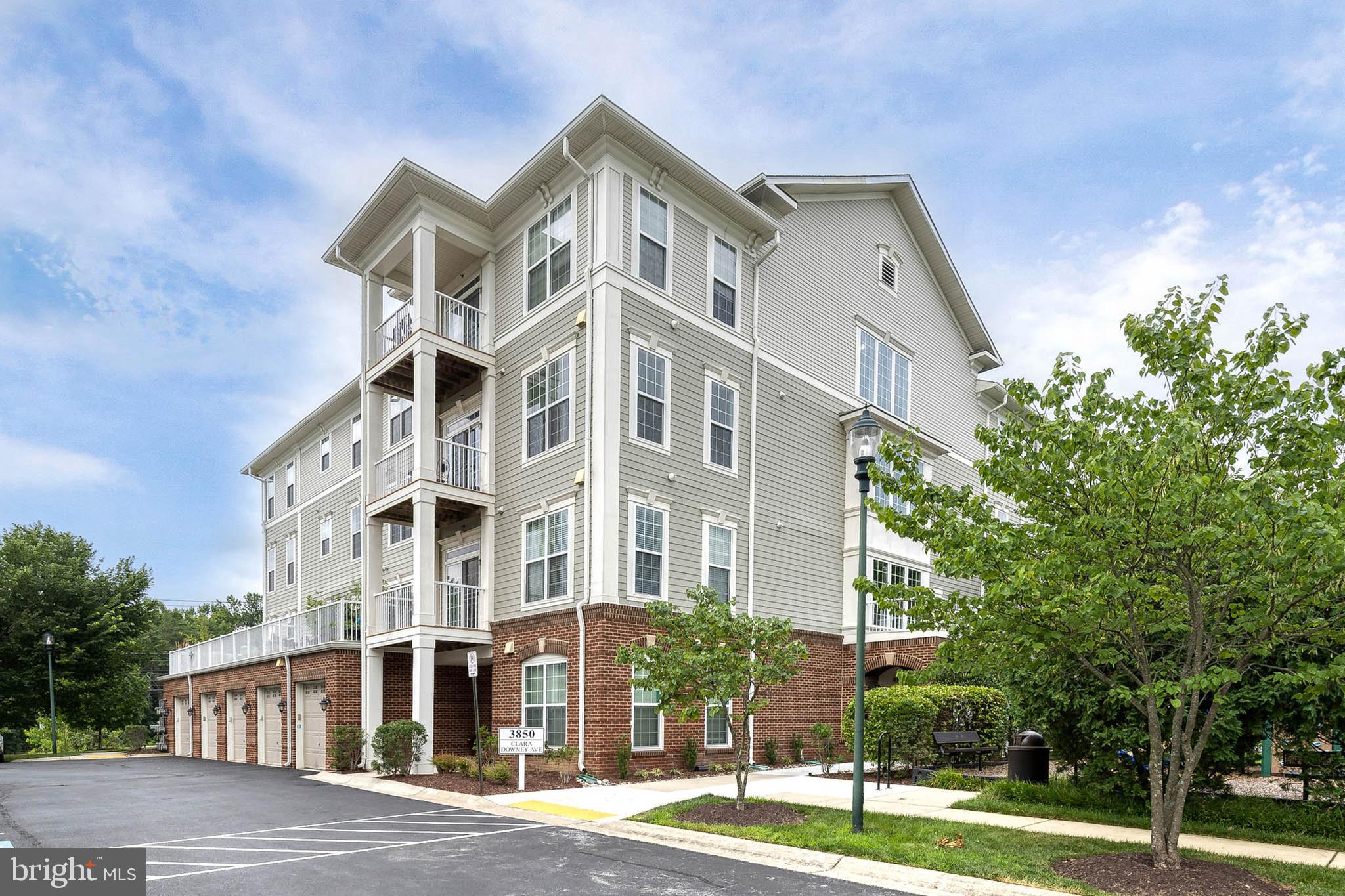 Welcome to this beautiful 1-bedroom, 1.5-bath condominium built in 2014, offering the convenience of main-level living with no steps or elevator required! The open-concept layout features soaring ceilings and a spacious combination living room, dining area, and kitchen, creating an inviting space for everyday living and entertaining. 

The living and dining areas are accented by plush carpeting, decorative chandelier, and sliding glass door leading to a private patio. The stylish kitchen boasts white cabinetry, stainless steel appliances, upgraded countertops that complement the cabinet hardware, pendant and overhead lighting, and a convenient bar-height countertop perfect for additional seating. A well-placed half bath adds extra convenience for guests. 

The spacious bedroom offers continued carpeting, a ceiling fan, and a striking emerald accent wall, while the ensuite bath features a matching emerald vanity and a beautifully tiled walk-in shower with sliding glass doors. Recent updates include a new dishwasher and garbage disposal (2025). Enjoy free, open parking and a tot lot playground located just outside the building entrance. Ideally located in Silver Spring with easy, low-maintenance living!