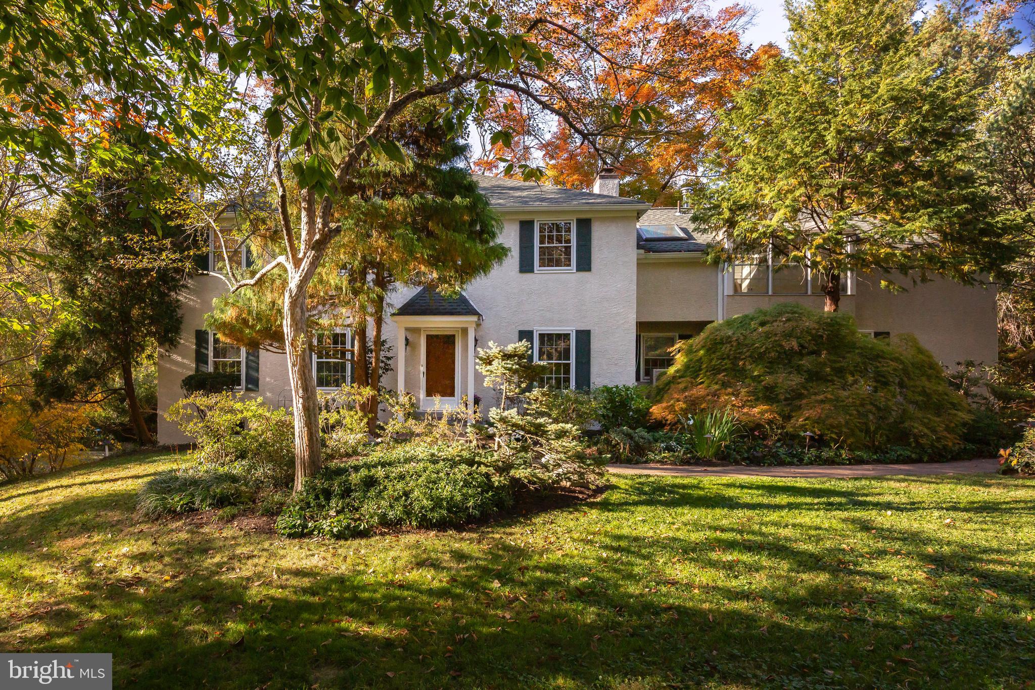 Discover this peaceful retreat in an ideal Bryn Mawr location! Set on a 1.74 acre lot at the end of a quiet cul-de-sac, this spacious home offers beautiful views and outdoor spaces. Stroll up the enchanting brick path leading to the front porch, and enter into the foyer with millwork, and wainscoting. Wood floors flow throughout the main floor living spaces, and large windows let in an abundance of natural light. The living room is a warm and inviting space, featuring a fireplace flanked by built-ins, while the dining room connects you easily to the outdoors with a glass slider to the oversized screened-in porch. A focal point of the home is the large updated kitchen with lots of wood cabinets, stainless steel appliances, a window over the sink overlooking wooded scenery, and bar seating. The kitchen opens to a cozy breakfast room with a fireplace and glass sliders to the deck and patio. Located off the breakfast room, there is a  family room that could be used as a home office or playroom, as well as a convenient mudroom area with laundry, powder room, and access to the patio and attached garage. The floor plan of this home lends itself to a busy modern lifestyle. Upstairs you will find the expansive primary bedroom suite, featuring two full en suite bathrooms. Enter into the sitting room (or office) where you will find the first en suite bathroom with a walk-in shower and a walk-in closet. Down the hall you will find another large closet and the second full en suite bathroom with a tub/shower before entering the spacious primary bedroom with vaulted ceiling, skylights, and a door to a terrace with outside stairs down to the patio. Three additional bedrooms share a hall bathroom with a tiled tub/shower, double vanity and linen closet. Utilize the finished lower level for storage and hobbies. Outside you will discover beautiful scenery and delightful paths to follow on the property, including bridges over Finn Run and Meadowbrook Run. Enjoy lovely views from your screened-in porch, deck and patio. This home offers easy access to local parks, Bryn Mawr and Rosemont train stations, Haverford College, and shopping and dining in Bryn Mawr, Ardmore and Suburban Square.