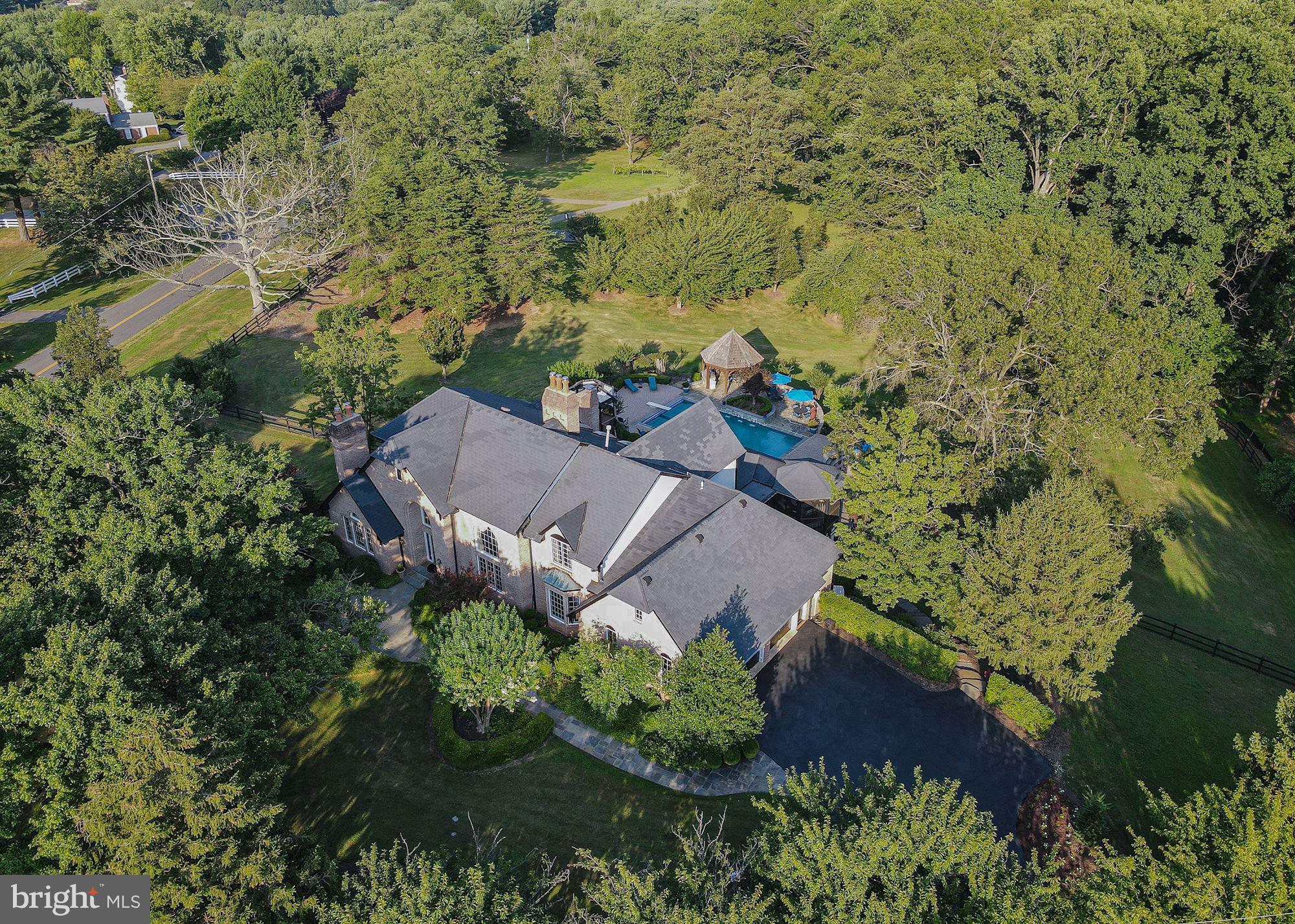 Your own private resort awaits you, welcome to 501 Scenic Way in pastoral Great Falls, Virginia.  Occupying 2.3 manicured acres, this estate blends elements of Tudor architecture with the classic Great Falls center-hall colonial aesthetic.  Whether seeking festivity or function, this home is certain to fit most any whim or desire.  Upon parking by the 3-car garage, you will marvel at the lush landscape as you approach the front entry leading to more than 8,000 finished square feet of luxury living.  With a flair for the formal, a handsome study greets you on the left, on the right- a grand formal living room with a two story ceiling, accented with extensive trim and moldings.  The kitchen & breakfast area open directly to a posh multi-level screened-in porch, with outdoor dining room, and comfortable living area with mounted tv, all overlooking the spectacular rear grounds.  The kitchen also flows into the formal dining room, via convenient butler's pantry.  As an added convenience, the owner's suite is situated on the main level, with a gas fireplace (one of 5 in the home), extensively built-out closets, grand bath with soaking-tub, separate shower, and an additional steam shower.  The main level is complimented with a walk-in pantry, and an accessory day-office that can be re-converted to a main-level laundry.The upper level sports 4 secondary bedrooms, three with ensuite baths, and a gallery overlooking the family room below.  The lower level offers an exceptional space for entertaining, including: a semi-enclosed zen garden with hot-tub, a changing room/pool-bath with convenient access to the outside, recreation room with wet bar & kitchenette, massive unfinished storage & main laundry, and a center for wellness equipped with cardio & resistance training equipment, and an adjacent day spa.  As sensational the interiors are, the outdoor experience at 501 Scenic Way will awe and inspire the active, while offering a peaceful sanctuary for relaxation & reflection.  The swimming pool has recently been converted to a saltwater-based system, with brand-new equipment including the pool heater.  The cascading lawns seem endless, tucked away behind the side perimeter fence.  Enjoy Summer evenings in the outdoor pavilion, with natural gas grill & accompanying refrigeration, and outdoor lounge area with a natural gas fireplace.  This retreat can be yours before the end of Summer, 501 Scenic Way is now available by appointment.  CDC guidelines apply for private tours.