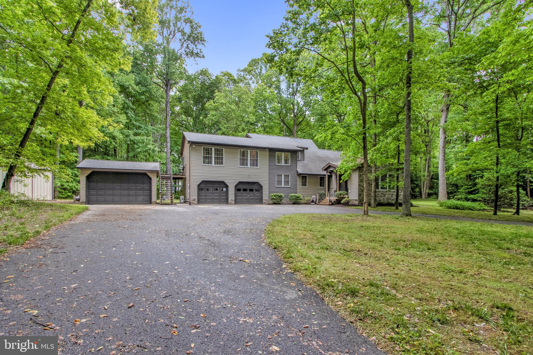 This beautifully remodeled multi-generational home is nestled in a wooded area at the end of a private lane In highly desirable Milton, offers a serene and secluded living experience.  Situated on 1.08 acres with no HOA restrictions, the property is conveniently located just a short drive from downtown Milton, Delaware Beaches, and local schools. The home features four bedrooms and three and a half baths, providing ample space for a family. Storage is abundant with spacious closets, a large mudroom, and an attached climate-controlled two-car garage. For additional outdoor storage, there is a large pole barn and a shed, both equipped with electricity. A detached two-car garage and a circular driveway offer parking for over 15 vehicles, including space for a boat, truck, or RV.  Inside, the open floor plan is enhanced by luxury plank flooring. The updated kitchen boasts cream-colored cabinets, granite countertops, and stainless-steel appliances. The first-floor master suite offers comfort with luxury vinyl plank floors and an en-suite bath. Upstairs, the master sanctuary is a highlight, featuring a private deck and a luxurious bathroom.  Additional bedrooms and a large hall bath are also located on this level, along with a bonus room.  Accessibility is a key feature, with 36" wide interior doors on the first floor and a ramp for easy access.  A large wood patio provides an ideal space for outdoor gatherings.  An adjacent  .75 Acres lot (235-25.00-27.06) can be  purchased in conjunction with the purchase of this property at a $725,000 price.  The .75 Acre lot  (235-25.00-27.06)  will not be sold independently.  For more information or to schedule a tour, please call. This property is a must-see for those seeking a spacious, accessible, and well-located home with plenty space and storage options.