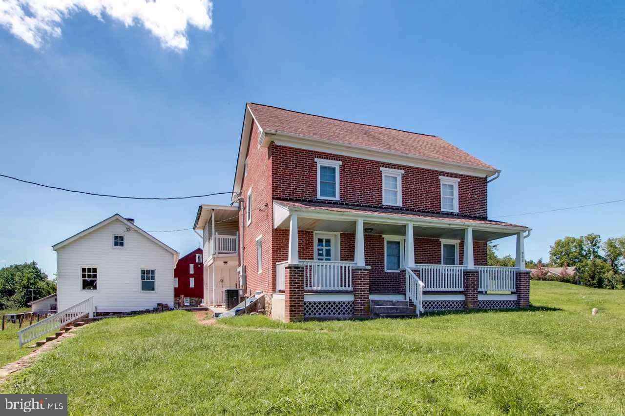 Restored log/brick farm house w/stone base barn, machine/equipment building, 3 bay with (2) 12' over head doors, 1 10' over head door, rear paved patio, kitchen with granite counter tops, summer kitchen.  Zoning is Agricultural Preservation