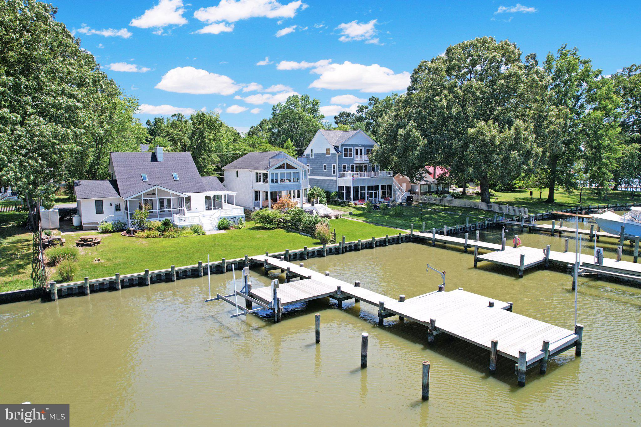 Exceptional value for this exquisite, recently renovated coastal waterfront retreat, offering the perfect blend of luxury, comfort, and breathtaking water views throughout. The home features three generously sized bedrooms, including a convenient main-level primary bedroom, and two elegantly appointed bathrooms.
The bright, open floor plan is enhanced by vaulted ceilings, recessed lighting, solar-powered skylights with built-in remote-controlled shades, and beautifully refinished oak hardwood flooring throughout the main level. Recent improvements include a new architectural-shingle roof, new upper-level carpeting in both bedrooms, new water treatment system, and professionally and tastefully painted inside and out.
At the heart of the home, the gourmet kitchen features solid wood white cabinetry, updated appliances, new quartz countertops, a huge center island with cooktop, prep sink, ample seating, and a spacious eat-in area—ideal for the culinary enthusiast as well as for everyday living and entertaining. The inviting great room, complete with a cozy gas fireplace, is the perfect place to relax and unwind and take in the wonderful views. 
Step outside to a beautifully landscaped, level 0.24-acre lot and enjoy your own private L-shaped pier with resurfaced decking, multiple slips, and a boat lift. A new bulkhead adds even more value to this exceptional property situated on South Creek, just off the West River and Chesapeake Bay—perfect for boating, crabbing, fishing, and enjoying life on the water. Take in the expansive views from the multi-level decks and adjoining screened-in area, creating an outstanding setting for relaxing and entertaining.
An oversized one-car garage provides additional storage, while the newly paved driveway offers off-street parking for six or more vehicles. Community amenities are complete with a swimming beach, dock, picnic area, and playground. Come experience the sought-after lifestyle of South County waterfront living—your dream coastal oasis awaits!
