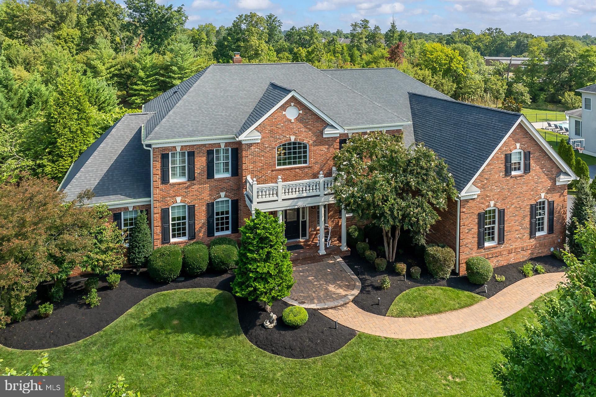 Unparalleled Elegance and Luxurious Estate in the esteemed Chase at Belmont Country Club neighborhood. This stunning property offers over 8,000 square feet of elegant living space on a premium .63 acre lot, nestled at the end of a quiet cul-de-sac. This exceptional property epitomizes luxury living, comfort and sophistication. As you enter through the grand foyer, you're greeted by the breathtaking double curved butterfly staircase, a dramatic focal point that sets the tone for the sophisticated floor plan throughout. The main and upper levels feature beautiful Brazilian cherry hardwood floors adding warmth and richness to every room. To the left of the foyer, the formal living room provides a perfect space for refined entertaining, with a sunroom just off to the side, offering a bright and relaxing space. On the opposite side, a formal dining room with beautiful wainscoting and chair moldings creates an ideal setting for hosting dinner parties. Nearby, the office includes custom built-in cabinets, offering the perfect workspace for remote professionals. At the heart of the home, the dramatic two-story family room impresses with its coffered ceiling and expansive windows that flood the space with natural light. Adjacent, the stunning gourmet kitchen is equipped with stainless steel appliances, a large center island with granite countertops, custom backsplash, and a breakfast nook for everyday meals. The luxurious primary suite is a serene retreat featuring a spacious bedroom with a sitting area, large windows and an elegant bathroom with a new jetted tub, separate upgraded shower, and dual vanities. The suite includes two walk-in closets, one of which is a customized oversized closet that is guaranteed to impress. Upper level balconies add to the home's charm and provide additional space to enjoy the beautiful backyard views. The expansive lower level is perfect for entertaining, featuring a full wet bar, a bedroom, full bath, along with a spacious craft room and abundant storage space. Step outside to your own private oasis featuring a spectacular and luxurious heated salt water swimming pool with a connecting waterfall hot tub. This symbolizes outdoor leisure at it's finest and includes a custom patio, extensive hardscape, and Trex deck, all backing to private common area and trees. Additional features include a 3-car side-load garage, tankless water heater, irrigation system, custom landscape lighting and more. Elementary and Middle Schools are within walking distance. With its elegant design, premium finishes, and exceptional location, this extraordinary estate home is a rare opportunity to experience luxury living in a truly magnificent setting.