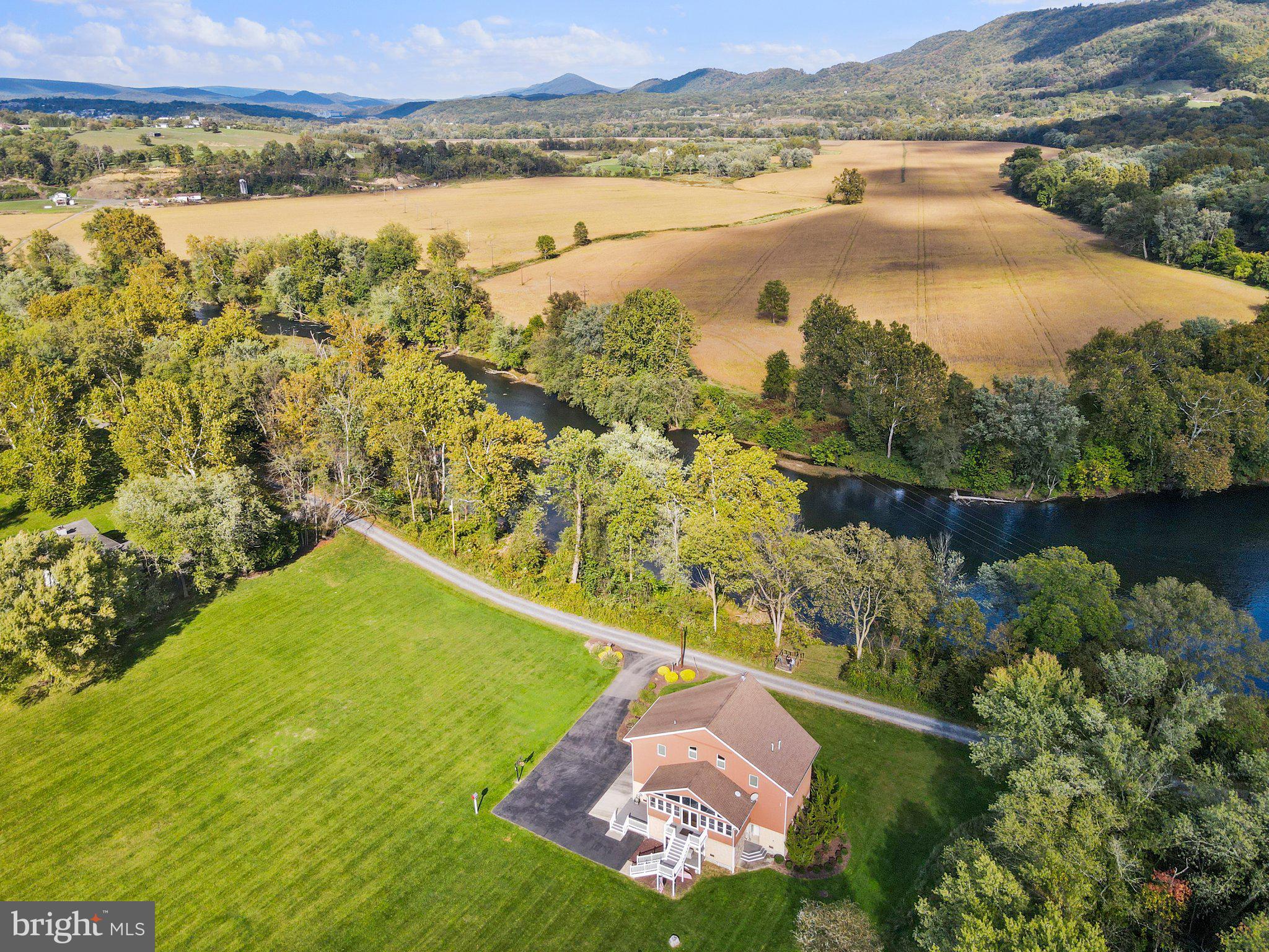 Hello Gorgeous!!! This beautiful home has 400' of river frontage on the North Branch of the Potomac River and sits on just over 9 acres of absolute beauty!  This custom built home has been architecturally designed to meet Maryland and FEMA flood plain requirements. Let's start on the main living area where the open floor plan allows easy flow from the kitchen into a jaw dropping great room with two stories of insulated windows overlooking the river. The kitchen has solid surface counters, wall oven and cook top. The primary bedroom has a huge ensuite bathroom with walk-in shower and adjacent walk-in closet on. This level also features a laundry room, pantry and additional bedroom with full bathroom. Just off the kitchen is an enormous three season sunroom with a propane heater to take the chill off.  Access to the homes amenities is helped by a three level 950 lb capacity residential elevator. Beautiful spiral staircase also accesses all three levels. Head upstairs to the 3rd level of living which features a loft area with incredible river views and additional bedroom and full bathroom.  Also have peace of mind when the winds blow that there’s a whole house Kohler propane generator to back up the power. Heating is forced air propane furnace and radiant floor heat can be used if desired. The split system efficiently heats and cools the home with double insulated spray foam and fiberglass with 2x6 construction, keeping you warm in the winter and cool in the summer! If you want to go with some old-fashioned warmth and ambience throw a log or two into the wood burning stove in the great room while you watch the snowflakes fall. The home has a two car lower-level garage and another garage storage area under the sunporch. Irrigation system helps keep that grass looking good with a controller in the game room area of the first level. Great place to kayak or canoe right out your front door and with the C&O Canal Towpath just a quarter mile away it’s ideal for those who want to be close to nature. The house also features a boat house (24x34) built to house the airboat he and his wife used to fly up the North Potomac to Cumberland in the warm months.  The sporting center in Cumberland features a boat ramp and plenty of parking.  The non-stop trip was just fifteen minutes. Of course, they often stopped to explore the river along the way or fish.  The deep water in front of the home was where the airboat was moored. It provided the place for the airboat to reach floating speed and pass over shallows without difficulty or damage to the boat. Family and friends looked forward to the rides when they visited during warm weather. The boat house is constructed with a high ceiling so that the boat and trailer could be backed into easily. It features large sliding doors, water and electric and is unobtrusively located on the property for all your oversized toys or tools.