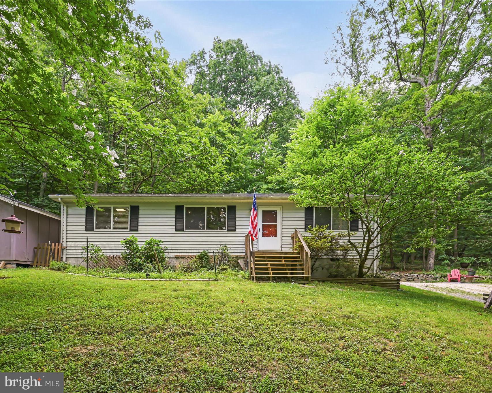 Welcome to 43 Tulip Ct, a charming retreat tucked away in a wooded setting off a private road with no HOA.  This move-in-ready ranch home offers 3 bedrooms and 2 full bathrooms, situated on a half-acre lot, providing the perfect blend of seclusion, peace, and everyday comfort.   Inside, you will find cathedral ceilings in the living room, creating an open and inviting atmosphere filled with natural light.  The well-appointed galley kitchen features abundant cabinet and counter space, along with a stackable washer and dryer.  The spacious primary suite offers a walk-in closet and private ensuite bath, while two additional bedrooms and a second full bathroom are thoughtfully located on the opposite side of the home.  Outside, enjoy your own peaceful backyard oasis. Relax on the expansive rear patio overlooking mature trees and a fish pond, creating the ideal setting for morning coffee, evening gatherings, or simply enjoying nature. A versatile storage shed provides extra space for lawn equipment, tools, and all your outdoor essentials.  Recent improvements include roof (2026), well pump and wiring (2025), water heater (2025), and HVAC (2020), to name a few, offering peace of mind for years to come. High-speed internet is also available.  
Great commuter location with easy access to Northern VA or Frederick, MD. Conveniently located near the Appalachian Trail, outdoor recreation, and just minutes from the Shenandoah River.  Schedule your showing today and experience everything this property has to offer!