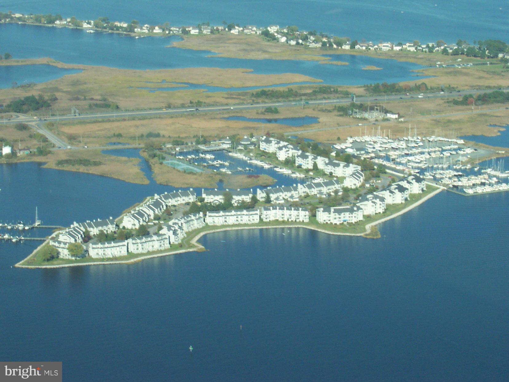 WATERFRONT VILLA!   Prof photos coming soon.  See your 40' deeded deep-water boat slip (M1PB03) from your deck!   Welcome to the peaceful, gated community of Oyster Cove   The western exposure of this 1-level condo has beautiful sunsets night after night!  It is situated on a protected marina and is near the pool!  This first floor 2-bedroom unit is completely updated with a contemporary design and boasts 9' ceilings and angled walls for your pleasure.  The great room features 40' of floor-to-ceiling windows with attractive valence, bright, OPEN floor plan, wains coating, crown molding, chair railing, TV and fireplace with  electric insert.  Gorgeous country kitchen has side-by-side refrigerator, breakfast bar with 3 bar stools,  pantry, lighted cabinets and Corian counters.  The spacious primary suite includes a double vanity, W-I closet and W-I shower.   The 2nd bedroom could be used as a home office or den.  The large waterside deck has ample seating plus a storage closet.  Luxurious clubhouse has been recently refurnished and features state-of-the art gym w/TV, handsome fireplace,  full kitchen and monthly socials - a great opportunity to meet your neighbors!  Holiday parties, game nights and "Oyster Talks" are also available for your entertainment.  Enjoy a morning stroll on the 1.5 mile walking path along the  water or a dip in the salt-water pool.  The pool opens at 6AM so you can enjoy a swim before the heat of the day.  There are multiple outdoor activities including tennis/pickleball, kayaks, jet skis and a dog park.  Walk to 5 restaurants!  Near 38-mile Cross Island Trail - great for biking, jobbing, dog walking, etc.   1-YR WARRANTY!  CHANGE YOUR ADDRESS AND CHANGE YOUR LIFESTYLE!