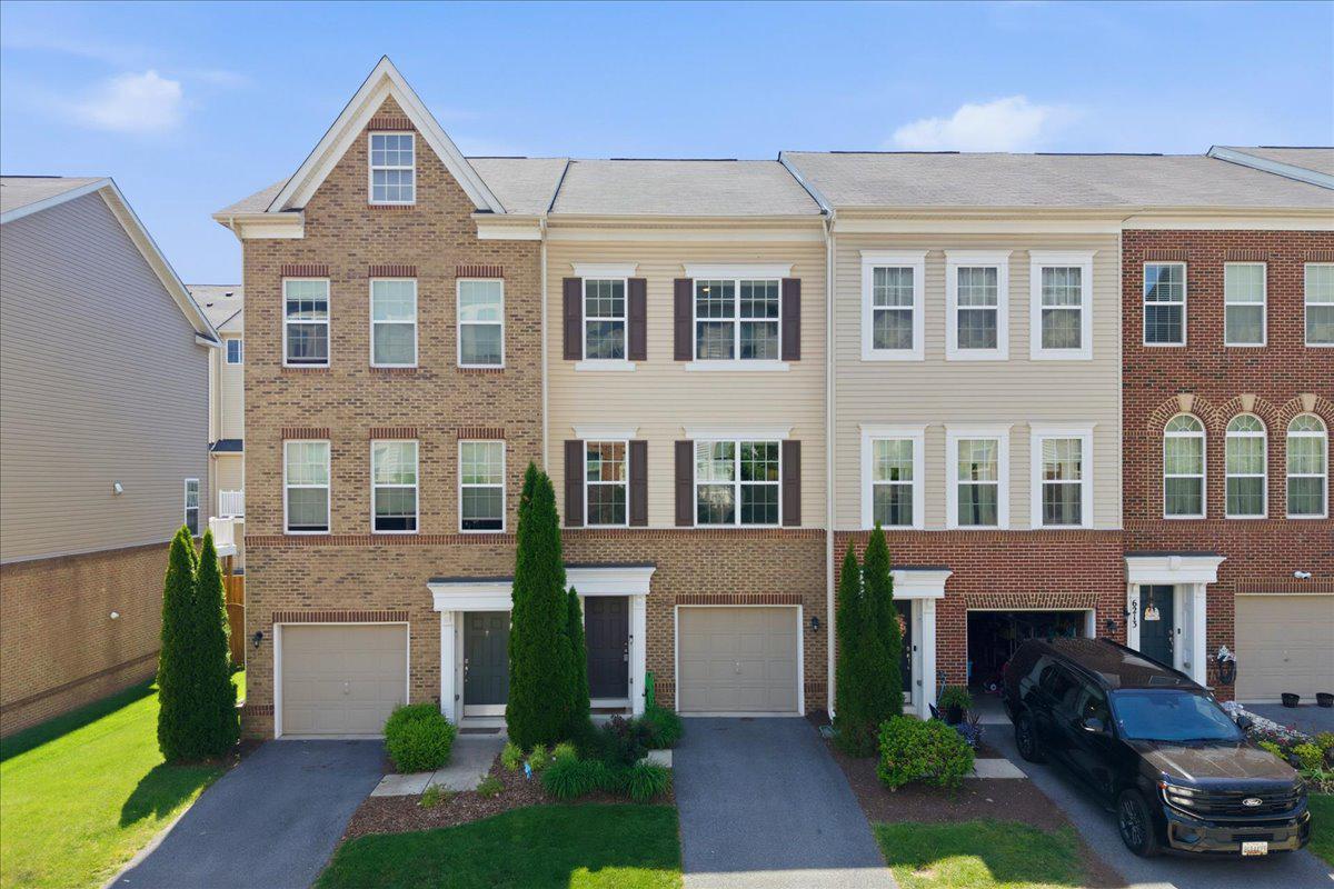 Welcome home to this stunning CalAtlantic home, previously known as Ryland Builders.  This three-story brick-front townhome offering two bedrooms, 2 full baths, 2 half baths, and a thoughtfully designed open floor plan across three finished levels. The bright entry foyer leads to a spacious lower-level recreation room with walkout to a private fenced backyard — ideal as a playroom, media room, or home office. The main level showcases a chef's kitchen featuring granite counters, rich cabinetry, gas cooking, large center island, and pantry, flowing into a sun-drenched breakfast area with deck access and an expansive family room with gleaming hardwoods. Upstairs offers two generous primary suites. One with walk-in shower and dual-sink vanity, and the other has a full bath. Convenient bedroom-level laundry, attached one-car garage, and a spacious rear deck complete the home. Enjoy resort-style amenities including pool, clubhouse, tennis & basketball courts, and playground — all framed by scenic mountain views. Located in Jefferson Place, Frederick with easy access to major commuter routes. Schedule your private tour today!