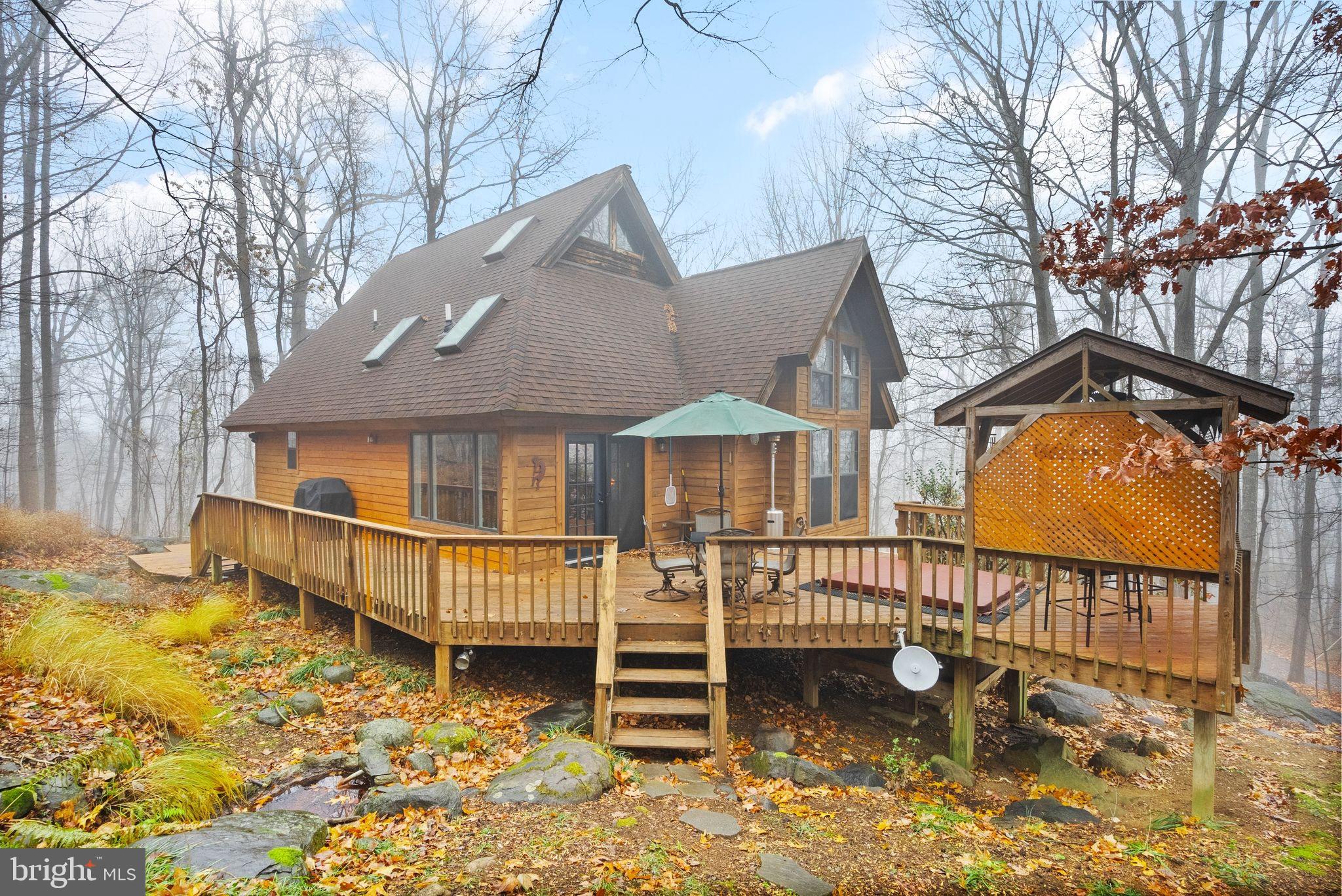 This is a one-of-a-kind property.  SF Homes in this area rarely go up for sale.!!! 
New Septic (2025),New roof/fascia (2022), Well Troll system (2022), four new skylights (2022), Fresh cedar siding on the back of the house.  HVAC  (2022), Whole house generator (2022), New flooring in the basement (2024), Hot water heater (2019), washer dryer (2024), Appliances (2023)
Welcome to this one-of-a-kind home nestled on 2.19 acres in beautiful Delaplane, Virginia, This unique retreat seamlessly blends natural beauty with sophisticated living. Ideal for a family home, weekend getaway, or tranquil living surrounded by nature. The rustic kitchen features custom quartersawn white oak (tigerwood) cabinets designed for the gourmet chef, complete with ‘soft close’ cabinet doors and deep custom drawers, under-cabinet lighting, and sleek black stainless steel appliances.  This space is enhanced by rich red oak flooring and copper pendant lights.

The dining room is illuminated by a large picture window and a new French door connecting the indoor and outdoor spaces. The living room and foyer feature Italian tile flooring and an upgraded woodstove, On the second floor, the primary bedroom features a walk-in closet with custom shelving with an adjacent bathroom. 

The third floor is a private oasis with a full bathroom with a walk-in shower, custom cabinets and shelves, a tile floor, and a vessel sink. The lower level is designed for versatility, featuring a spacious family room addition with custom built-in shelves on two walls, a new entry door, and ample space for relaxation. A full bath and laundry room additions with brand new LVP flooring with an additional recently upgraded bedroom with LVP flooring and French door, a perfect guest or family room.
Step outside to fully embrace the mountain lifestyle on the expansive wrap-around deck complete with a covered cabana and a relaxing hot tub perfect for unwinding at the end of a long day.  while the elegant water fountain features add a touch of tranquility to your outdoor experience.  

Conveniently located less than an hour from major cities, shopping, and with easy access to Interstate 66, numerous wineries and breweries. Nestled in Virginia's stunning wine country, this home offers unparalleled access to top wineries like Barrel Oak, Delaplane Cellars, and RdV Vineyards, perfect for leisurely afternoons of wine-tasting and breathtaking views of the Blue Ridge Mountains. Nature lovers will enjoy nearby Sky Meadows State Park, with its scenic hiking trails and picnic spots, and the quiet charm of the Chapman DeMary Trail in Marshall. Just a short drive away, the G. Richard Thompson Wildlife Management Area and Shenandoah River State Park provide even more options for outdoor adventures, all within reach of this inviting Delaplane retreat. This Delaplane mountain retreat truly combines luxury, modern amenities, and exceptional craftsmanship, making it a truly unique and inviting home. For commuters, the University Boulevard Park & Ride Lot in Gainesville is a short 30-minute drive away.