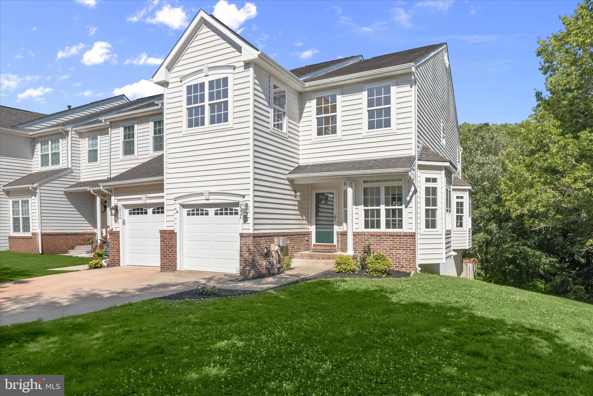 Completely updated end-of-row townhome in Laurel's sought-after, amenity-rich community! Stylish renovations include remodeled bathrooms, new flooring, fresh paint, updated lighting, refreshed kitchen finishes, new microwave, washer, dryer, and more. A bright and airy floor plan begins with a sun-filled dining room surrounded by windows that fill the space with natural light.  The open-concept main level offers a spacious family room with a gas fireplace, new recessed lighting, and seamless flow into the kitchen and breakfast nook. Kitchen updates include quartz countertops, refreshed cabinetry, and modern finishes. Sliding door access from the breakfast area leads to a private deck overlooking a peaceful tree-lined setting. An updated powder room completes the main level.  Upstairs, the impressive primary suite features a soaring vaulted ceiling with skylight, large walk-in closet, and beautifully remodeled bath with dual vanity, soaking tub, and frameless glass shower. Two additional bedrooms, an updated hall bath, and convenient laundry room complete the upper level.  The finished walkout lower level adds exceptional living space with new luxury vinyl plank flooring, a recreation room with patio access, a fourth bedroom, full bath, and fenced backyard perfect for outdoor enjoyment.  Community amenities include a clubhouse with gathering space and full kitchen, fitness center, swimming pool, and tennis courts. Ideally located near major commuter routes, shopping, dining, and entertainment, this turnkey home offers the perfect blend of style, comfort, and convenience.