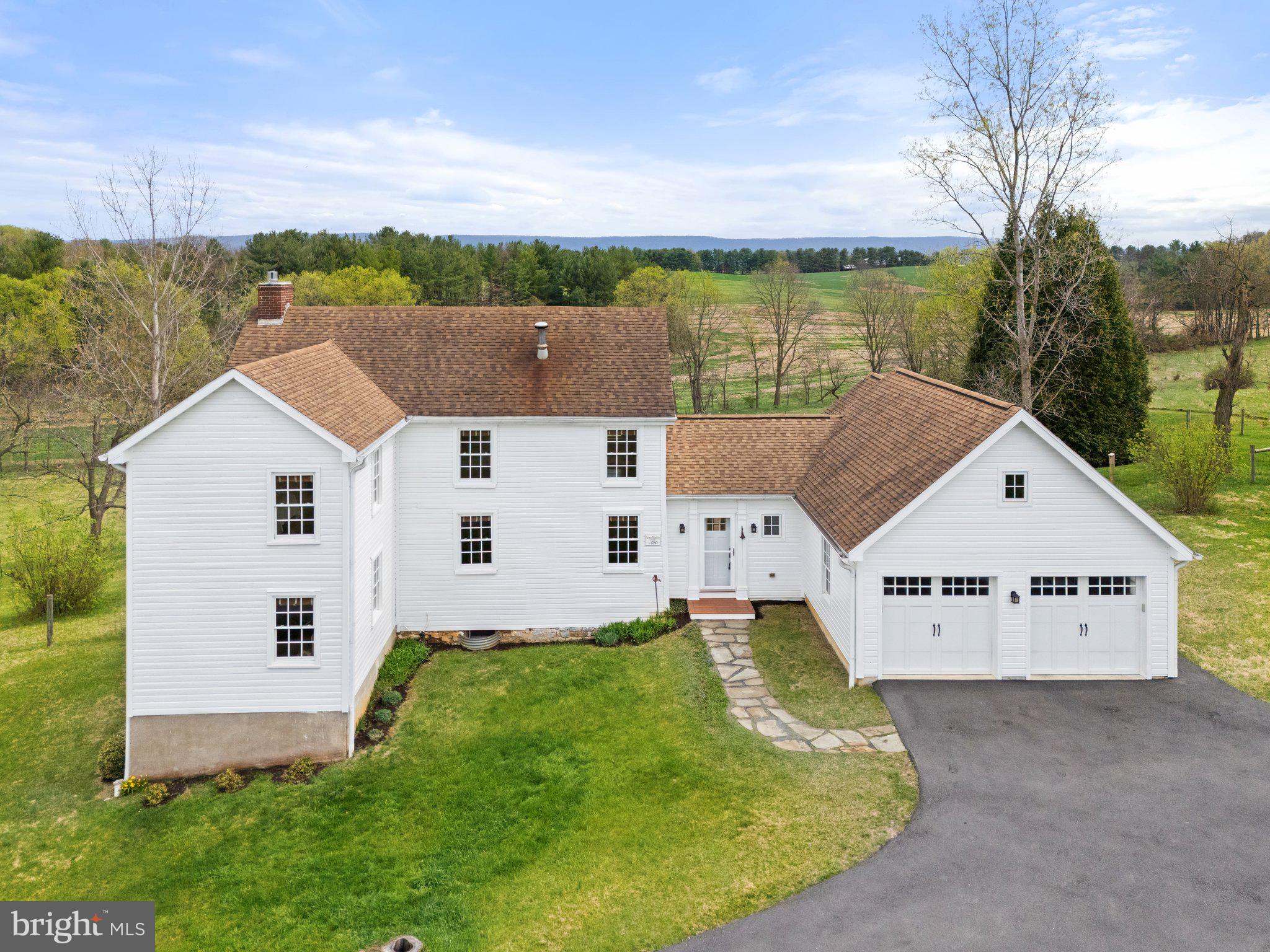 Step back in time and experience the charm and character of this 1780 log farmhouse—an exceptional home for those who appreciate antique craftsmanship and the stories of the past. Originally owned by George Morgan, a Revolutionary War soldier who fought alongside Gen. Washington at Piscataway in 1776, this home stood as a silent witness to generations of history. By the early 1800s, the property was passed to Walter Selby, a prominent Shepherdstown merchant, who leased the property to tenant farmers. His daughter, Eliza, later married Col. John Francis Hamtramck, a man appointed by President John Quincy Adams to serve as Indian Agent to the Osage Nation. The winding driveway brings you to the home’s attached two car garage where you also have ample driveway parking space. Walking through the front door you instantly feel as though you are journeying back in time. Upon entering, your first stop should be the inviting porch with three skylights, a metal roof, relaxing swing & ceiling fans—a welcoming space to unwind and take in views of the private pond, fenced pastures, surrounding farms, and the Blue Ridge. To the side of the home stands a modern 30x40 pole barn and access to a mile of scenic mowed trails, some lined by native dogwoods, that wind throughout the rolling 10-acres. Inside, exposed wooden beams, original brick walls, and a converted gas fireplace (2020) create a warm, inviting atmosphere with plenty of natural light that highlights all the wonderful features of this home. The 1929 parlor addition features built-in cabinetry and a trapdoor leading to the walkout basement, with its original stone cooking hearth, adding unique character to the home. Recent updates, like the addition of double-pane high efficiency windows throughout & energy-efficient heat pumps, ensure comfort without compromising the home’s timeless charm. The kitchen features Craftmade cabinetry, complete with pull-out drawers, pairs beautifully with a Five Star six-burner gas stove with a griddle, gas oven, plus an electric convection oven. It also overlooks the heart of the home where loved ones can gather. A private staircase leads to a bonus space on the upper level, perfect for a home office or guest space. This room has an additional staircase to a fully floored attic that offers plenty of storage. You'll find three spacious bedrooms that reflect the home’s enduring character. Heart pine floors and the remnants of a closed-off fireplace continue the home’s legacy. A full bath with open-beam ceiling, a soaking tub with rainfall shower, and separate water closet complete the second floor. A second stairway brings you back down to the living room.
In 2014, an architect-designed primary suite addition was built featuring heavily insulated exterior walls, antique doors, and old rim locks with ceramic knobs. This suite includes a walk-in closet, en-suite bath with tile floors, dual-sink vanity, antique reproduction medicine cabinets, beautifully tiled shower with a bench seat & frameless glass enclosure. The main-level laundry & powder room add to the home’s functionality. Many closets are sprinkled throughout, there is no shortage of space to store your items. With three heating zones, plus supplementary heating in the bathrooms, this home ensures comfort year-round. Key updates include a high efficiency German-made Buderus oil burner & boiler, new oil tank & HVAC in 2015, a newly drilled well (1.5 years ago), water softener, sump pump, large pressure tank, and carbon/sediment filtration. From the 1840s Greek Revival-style window trim to the gas fireplace, every corner of this home tells a story & you can read all about it in a book by the current owner called ‘Frontier Cabin Story: The Rediscovered History of a West Virginia Log Farmhouse.’ It’s not just a house—it’s a connection to the past and to the history of Shepherdstown and the wider Eastern Panhandle of WV waiting for its next steward.