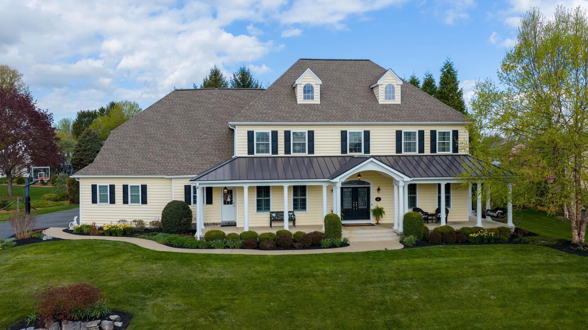 Welcome to 517 Wheatfield Drive, where timeless design, exceptional space, and resort-style living come together.  Located in the highly sought-after Manheim Township School District, this home offers over 5,500 square feet of beautifully finished living space.

From the moment you arrive, the home’s classic curb appeal, expansive front porch, and manicured grounds create a warm and inviting first impression.  Inside, a light-filled foyer opens to thoughtfully designed living spaces featuring rich hardwood floors, custom millwork, coffered ceilings, and a seamless flow ideal for both everyday living and entertaining.

At the heart of the home is a beautifully designed kitchen, featuring two islands - including a spacious dual-level island with seating, abundant cabinetry, granite countertops, a five-burner gas cooktop, double ovens, and effortless connection to the dining area and great room. The adjacent living space offers custom built-ins and a fireplace, creating a comfortable yet refined gathering space.

Just beyond, a light-drenched sunroom showcases a striking stone fireplace and panoramic views of the backyard, offering the perfect space to relax and enjoy indoor-outdoor living year-round.

The main level also features a thoughtfully designed layout with a bedroom and full bath - ideal for guests or multigenerational living - along with a dedicated first-floor office with custom built-ins, perfect for working from home.  A well-designed mudroom and half bath adds everyday convenience.

Upstairs, the primary suite serves as a true retreat, featuring a spacious layout and a beautifully appointed en-suite bath with dual vanities, soaking tub, and walk-in shower.  Two additional bedrooms each offer en-suite baths, while a large bonus room provides flexible space for a fifth bedroom, media room, or playroom.

The finished lower level is designed for entertaining and relaxation, featuring a full bar, expansive living area, fireplace, and a dedicated fitness space - perfect for hosting gatherings or creating your own private retreat.

Step outside to a backyard that truly sets this home apart.  The fenced yard is designed for both relaxation and entertaining, offering a heated in-ground pool, covered patio with ceiling fans, a fully equipped outdoor kitchen, and multiple seating areas - all surrounded by mature landscaping for added privacy.

A three-car garage and generous storage throughout complete the home’s exceptional functionality.

This is your opportunity to enjoy exceptional living in one of Manheim Township's most desirable locations.