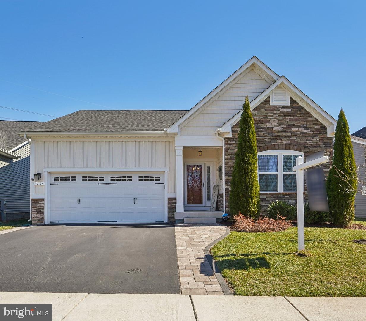 Get ready to embrace this lifestyle in this inviting home and community. The Sanctuary at Two Rivers and this three- or two-bedroom home with an office and three full baths was built with an optional extended Kitchen and dining area. The extra square footage is not reflected in the tax records. The modern kitchen with a large island, gas cooktop, wall ovens, and additional cabinet space (due to the extended floor plan) is open to the living room with an upgraded stone fireplace. There are hardwood floors throughout the main level. Retreat to the mostly finished lower level and enjoy the shiplap wall featuring an oversized wet bar with two beverage refrigerators and cabinet space. There is also a full bath on this level. There is a double-door walk up to a newly created private oasis. The outdoor living space includes a composite deck with a sunk-in Hot tub, dining, and lounging areas. The paver patio area backs to trees and is beautifully landscaped. This 55+ active community offers wonderful amenities, including indoor and outdoor pools, pickleball and tennis courts, and wonderful meeting spaces within the clubhouse. There are events and activities for all interests.