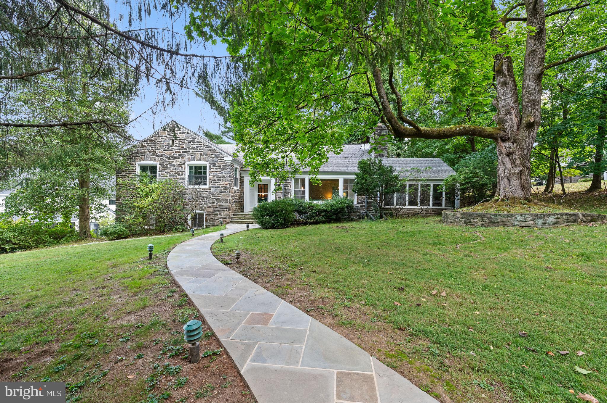 Welcome to this classic "Mahoney" built gem, just waiting for the new owners to make it shine!  This home is on Beech Hill Road, one of the most coveted picturesque streets in Northside Wynnewood. Situated in the award winning Lower Merion School District, this home has the best of everything!  It is a 3 bedroom Cape Colonial, situated on a very large .48 acre lot. Pull in the long, private driveway and immediately admire this gorgeous beautifully appointed stone home!  Enter the front door from a meandering flagstone walkway.  To the right of the light filled foyer, is an extra large living room complete with a beautiful mantle and gas fireplace.  Off of the living room is a sunroom/enclosed porch, perfect for a playroom, family room or home office.  The formal dining room has a picturesque window overlooking the backyard grounds. The eat in kitchen offers a door into the dining room , and also offers rear entry to the driveway.  The 2nd floor includes an extra large primary bedroom with a private ensuite bathroom.  On this level is also another bedroom and a full hall bathroom.  Go up a few more steps to a 3rd large bedroom and another full bathroom. This home boasts beaming hardwood floors throughout!  The attic area is unfinished, but certainly has potential to be finished off as another bedroom or playroom.  The laundry area is located in the large unfinished basement with and half bathroom, which also has wonderful potential for additional finished space.  The basement leads you directly to the 2 car attached garage.  In the rear of the garage, there is an added bonus room, complete with a closet, windows, and another full bathroom!  This could serve as an office, an in-law suite or workout room. While on a quiet, pristine street tucked away in a beautiful neighborhood, this home is also located in an ultra convenient location!  It is just a little over a mile walk to Suburban Square Shopping Center featuring Trader Joe's, Lifetime Fitness, popular restaurants and much more!  This location is also just a little over a mile to 2 different SEPTA stations for a short ride to Center City, and one of these stations (Ardmore) takes you directly to NYC.  Being sold in "as is" condition, bring your vision and dreams - and do not miss this incredible opportunity!