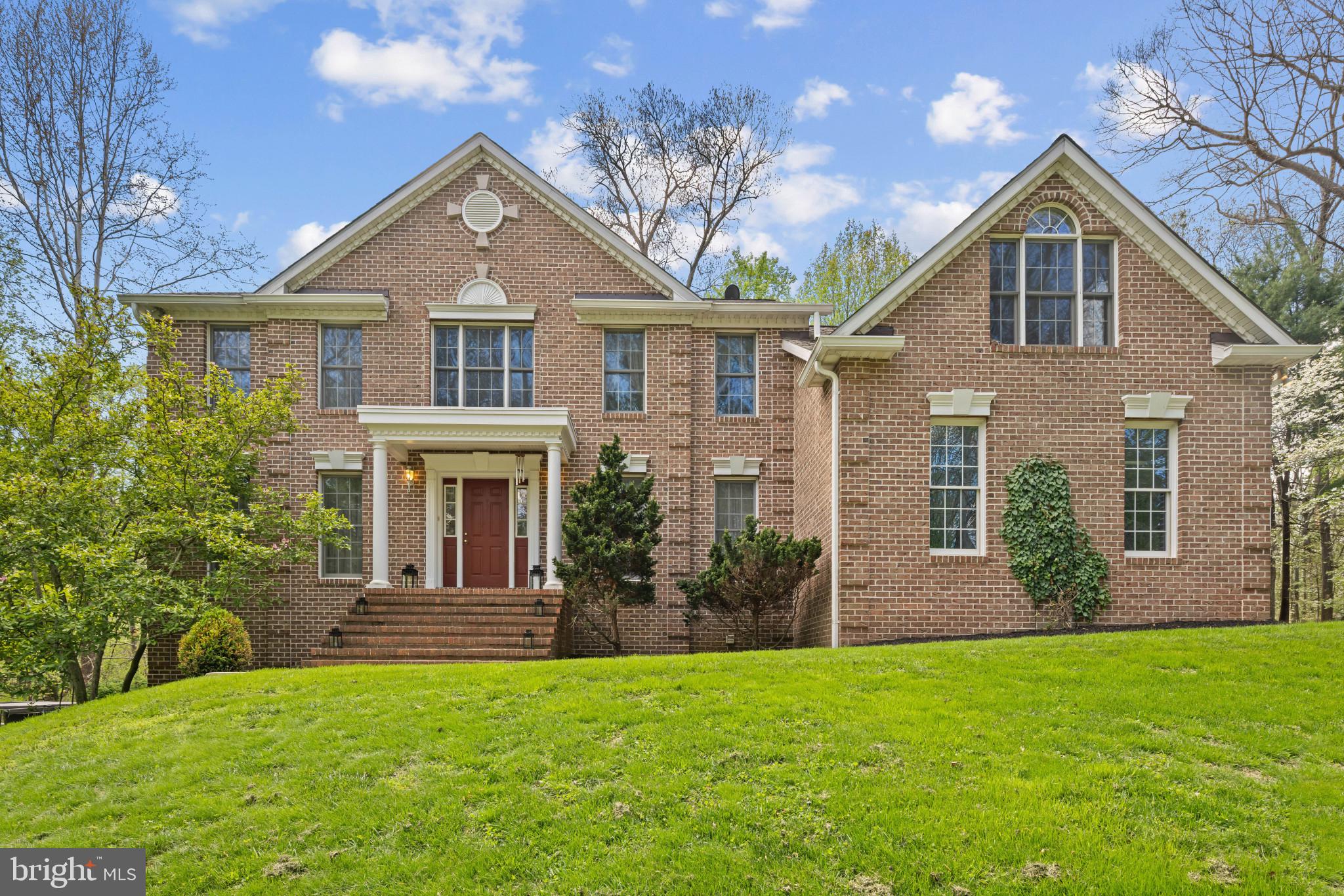 A private woodland retreat defined by elegance and craftsmanship, this custom-built 3,704 sq. ft. brick Colonial is set on 5 breathtaking acres. A long, scenic approach sets the tone, offering a sense of arrival and seclusion just minutes from major commuter routes. Inside, refined design meets everyday comfort. The gourmet kitchen features expansive counter space, premium cabinetry, and a center island, all opening seamlessly to a light-filled family room. The vaulted family room impresses with a striking stone wood-burning fireplace, while walls of windows frame the surrounding landscape, creating a seamless connection to the outdoors. Step outside to a sprawling two-tier deck—ideal for entertaining, outdoor dining, or quiet moments immersed in nature. A true birder’s haven, where the mature woodland setting fosters a rich and ever-changing array of birdlife. Upstairs, the serene primary suite offers a spacious walk-in closet and a luxurious en-suite bath with a soaking tub and separate shower. Three additional generously sized bedrooms share an updated hall bath, providing comfort and flexibility for family or guests. The finished lower level adds exceptional living space, featuring a custom bar, expansive recreation area, and walk-out access to the backyard—filling the space with abundant natural light and creating a bright, inviting extension of the home. Ideal for entertaining, hobbies, or a private retreat. Every window captures picturesque views, enhancing the home’s tranquil atmosphere. Ideally located in a highly sought-after area of Finksburg, this property offers the perfect balance of privacy and convenience, with easy access to major routes, shopping, and dining.