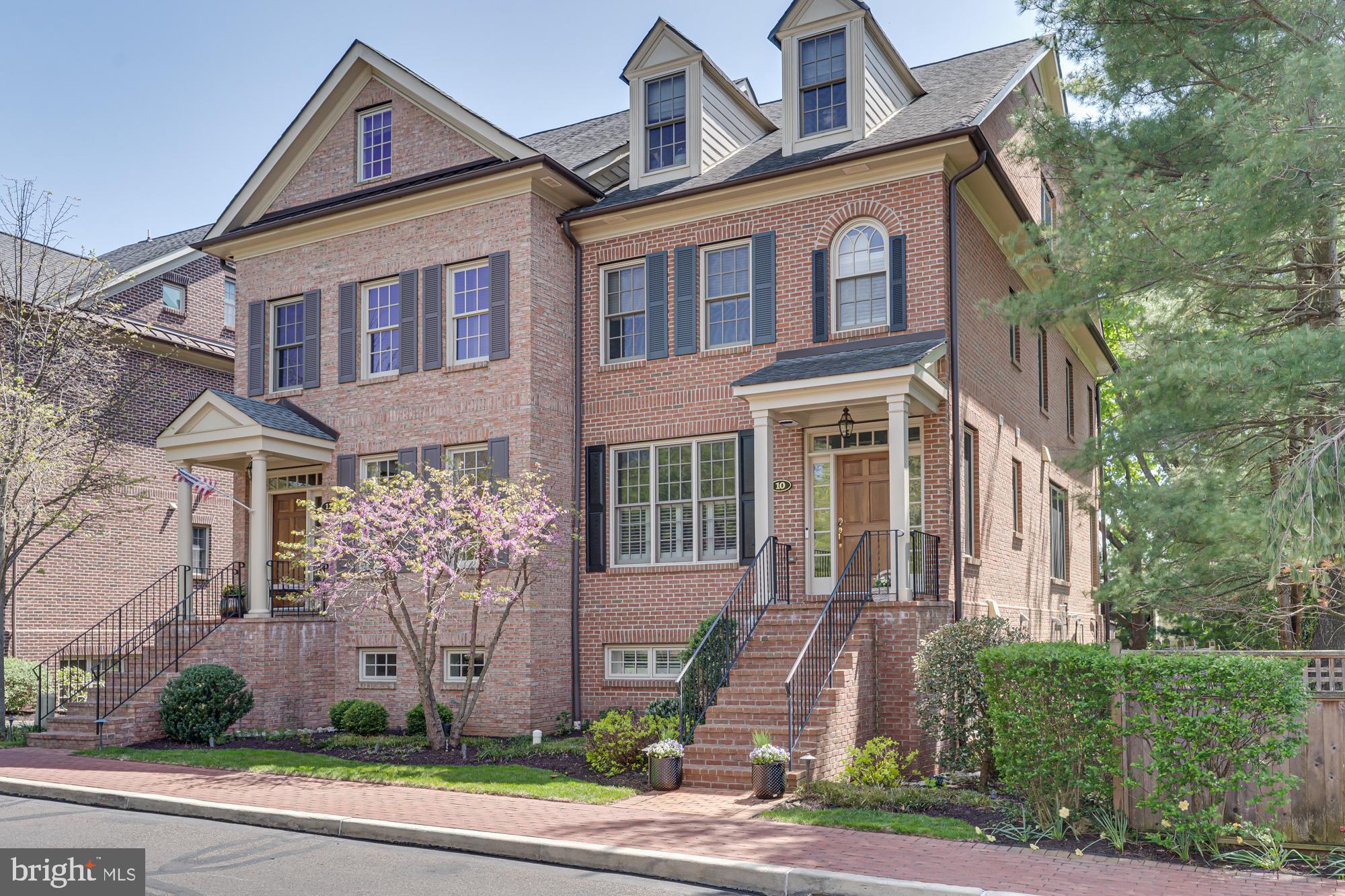 Discover this beautifully appointed brick twin nestled in the bucolic Phillips Court neighborhood of Newtown Borough. This exceptional residence offers a seamless blend of comfort, style, and convenience, highlighted by a light-filled open floor plan and a private elevator servicing the garage and main living levels.
Upon entry, refined architectural millwork, designer lighting, and rich hardwood floors set an elegant tone. The gracious foyer opens to a stunning dining room, thoughtfully designed for both intimate gatherings and formal entertaining.
At the heart of the home, the gourmet kitchen is as functional as it is striking—featuring a Sub-Zero refrigerator, six-burner Wolf gas range, wine refrigerator, crisp white cabinetry with accent lighting, and sophisticated marble countertops. A generous center island invites guests to gather, while the adjoining dining area flows seamlessly into the great room.
The great room offers a warm and inviting atmosphere, highlighted by a gas fireplace flanked by custom built-in display cases and complemented by plantation shutters found throughout the home. Expansive glass doors lead to a private slate terrace overlooking mature trees—an ideal setting for quiet evenings or alfresco dining with friends.
The second level is anchored by a magnificent primary suite, offering a serene bath retreat featuring a whirlpool tub, an expansive double shower with natural tile, and a double vanity. An exceptional walk-in closet, along with two additional closets, provides abundant storage. A spacious second bedroom with its own private bath, and a convenient laundry room with utility sink complete this floor.
A third level offers remarkable flexibility, ideal as a private guest suite with full bath and separate sitting area, or as a media and gathering space as currently enjoyed. An additional room on this level lends itself beautifully to a quiet home office, fitness studio, or cozy reading retreat.
The finished lower level creates an inviting extension of the home, featuring a wet bar, wine refrigerator, and powder room—perfect for entertaining or relaxing while enjoying sports and movies. A two-car garage, equipped with an electric vehicle charger, offers everyday convenience and is easily accessed by the elevator.
Enjoy the convenience of in-town living with a short stroll to Newtown Borough’s renowned restaurants, coffee shops, and boutiques while residing in a private enclave of refined homes.