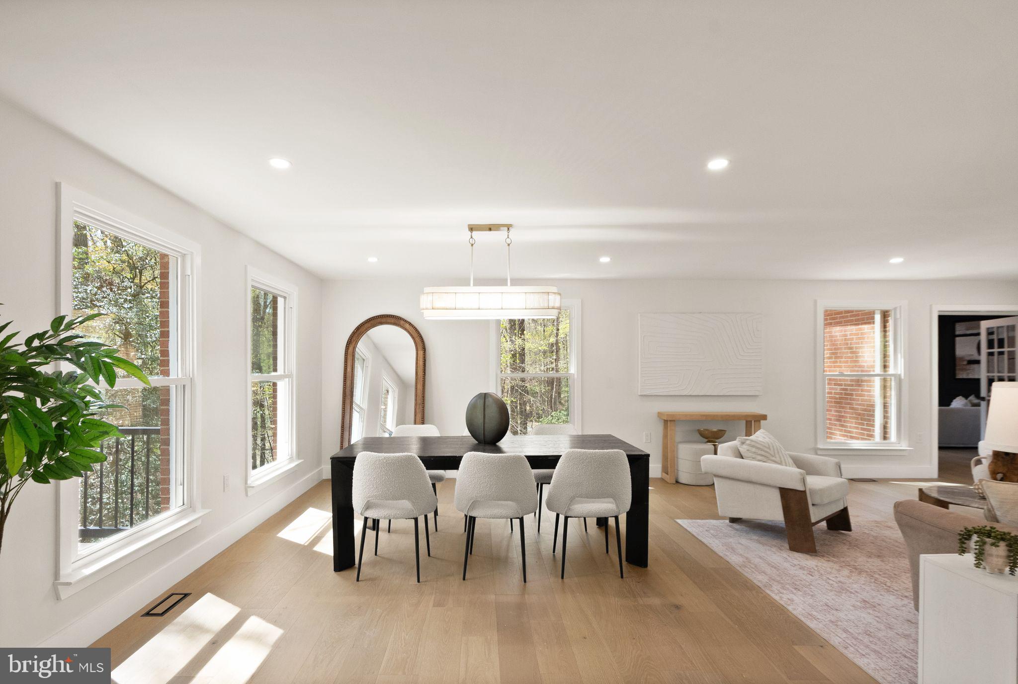 This classic Great Falls estate has been completely reimagined and renovated with top‑of‑the‑line finishes and carefully curated design that fuses modern elegance with everyday function. Set on a serene, wooded 5‑acre lot, the nearly 7,000 sq ft of living space is move‑in ready and offers something for everyone. The main level showcases a gourmet chef’s kitchen with a 12' attached pantry, designer induction dual oven, striking hood, two dishwashers and a Cafe Series refrigerator—ample room to cook and entertain. The kitchen opens to a beautifully designed wet bar with custom Cafe beverage drawers and to a dramatic brick‑front hearth with wood‑burning fireplace that frames views of the private backyard. Seamless indoor‑outdoor living is perfected by the new main‑level deck, while the open living and dining rooms balance everyday comfort with the grace to host the most lavish affairs. The main‑level Great Room is an inspiring retreat, finished with custom moldings and abundant windows that flood the space with natural light. This exceptional property blends refined finishes, smart layout and peaceful acreage to create a rare Great Falls opportunity.