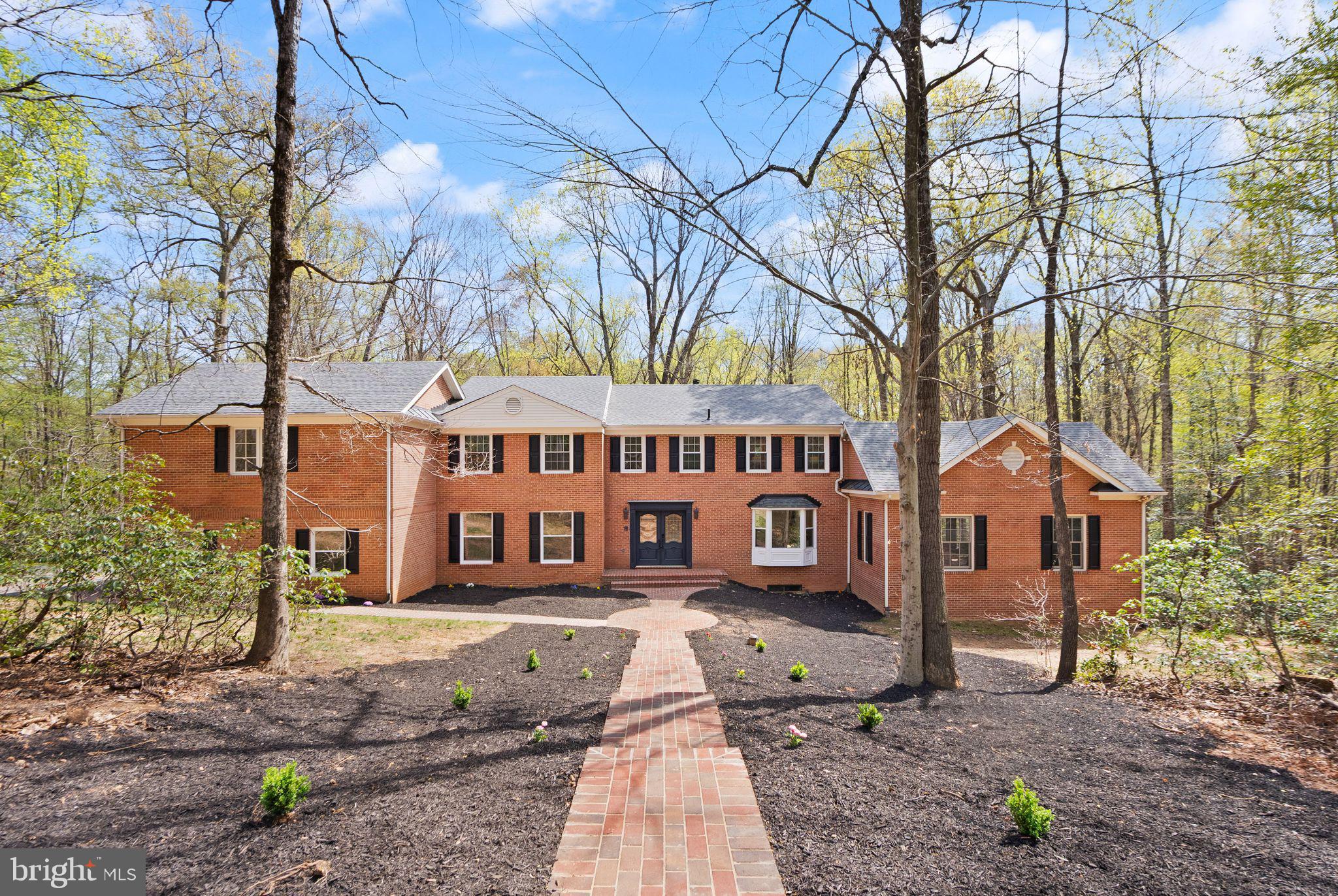 This classic Great Falls estate has been completely reimagined and renovated with top‑of‑the‑line finishes and carefully curated design that fuses modern elegance with everyday function. Set on a serene, wooded 5‑acre lot, the nearly 7,000 sq ft of living space is move‑in ready and offers something for everyone. The main level showcases a gourmet chef’s kitchen with a 12' attached pantry, designer induction dual oven, striking hood, two dishwashers and a Cafe Series refrigerator—ample room to cook and entertain. The kitchen opens to a beautifully designed wet bar with custom Cafe beverage drawers and to a dramatic brick‑front hearth with wood‑burning fireplace that frames views of the private backyard. Seamless indoor‑outdoor living is perfected by the new main‑level deck, while the open living and dining rooms balance everyday comfort with the grace to host the most lavish affairs. The main‑level Great Room is an inspiring retreat, finished with custom moldings and abundant windows that flood the space with natural light. This exceptional property blends refined finishes, smart layout and peaceful acreage to create a rare Great Falls opportunity.