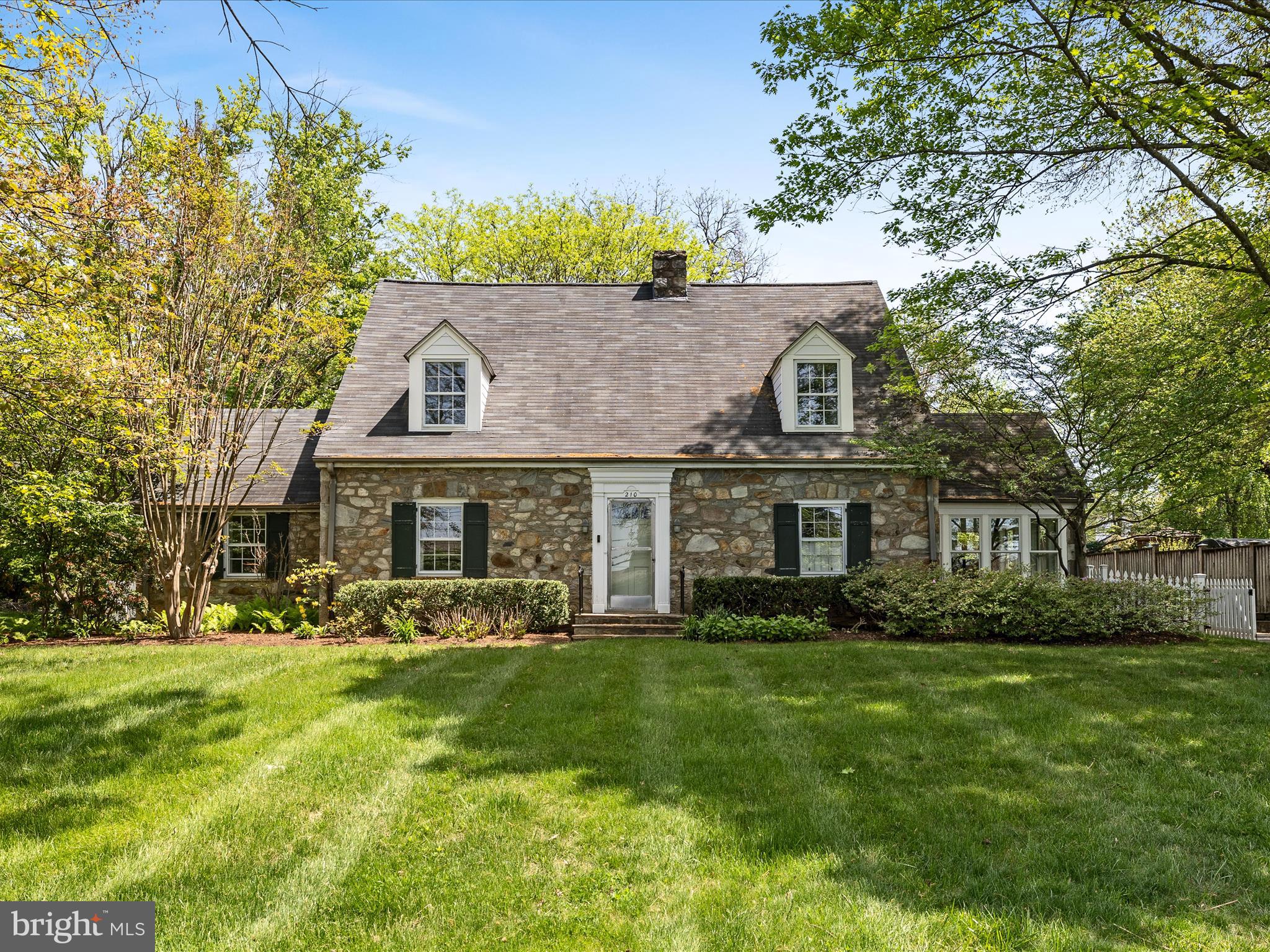 Rare opportunity to acquire this 4-sided solid stone Cape Cod style home built in 1941, when craftmanship and masonry were an art.   Situated on almost a half-acre in the Town of Purcellville Historic District, a recognized historic district by the Virginia Landmarks Register and the National Registry of Historic Places.  This well maintained and upgraded,  3-4 bedroom and 2.5 bath home offers a traditional floor plan with spacious rooms and wide hallways.  This home boasts charm, tradition and classic elegance from a simpler era when everyone knew their neighbors who may have stopped by to borrow something, share a story  or a meal together. You will find solid hardwood flooring on both levels. Crown molding and chair rails throughout the main level.  French doors, pocket doors to separate the bustle of the kitchen from the dining room. Six panel doors can be found on the bedroom level as well as built in drawers and multiple closets of various shapes and sizes.  Attic storage accesses are on both ends of the home through little doors, leading to what could be used for storage or redone for a child’s magical play area. From the kitchen windows, see the gardens and watch the birds all the while having morning sun pour in to greet you. Abutting the kitchen  is a much-desired butler’s pantry complete with a deep sink, pull out shelving, drawers and cabinets. The front to back living room has built-in bookcases and cabinets to store your library.  The windows have wide sills that serve as a wonderful location for your house plants. Privacy is provided by the wooden window shutters.  Sit by the stone wood burning fireplace and read. Sunlight pours in from early morning sun to late afternoon sunset.Enjoy the gardens from the sunroom/den or on the outdoor patio. The gardens have something blooming all year round. There is a fenced area for little ones or furry friends. Shed for storing gardening tool plus. Stone walks and stone walls. There is a large asphalt parking area and white picket fence entry gate at the driveway. Close proximity to all that Purcellville offers, schools, restaurants, community center, Bush Tabernacle roller skating rink, Fireman's Field for baseball, Franklin Park sport park, the library and parade routes.  Make 210 32nd Street your next place to call "Home"!