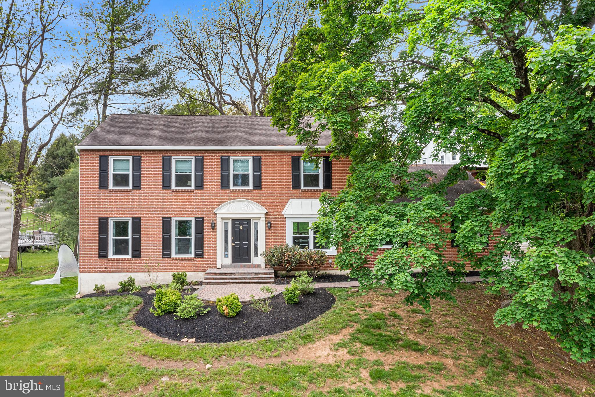 Commanding a premier hilltop position on a quiet cul-de-sac directly across from the West Chester Country Club, and moments from the acclaimed shops and dining of downtown West Chester, this completely renovated brick colonial is the rare home that offers both an exceptional address and a turnkey interior refined at every turn. Cross the threshold and discover what classic brick colonials rarely deliver: an interior that has been wholly reimagined for the way we live today. The inviting foyer opens with immediate impact, fresh paint, newly installed luxury vinyl plank flooring, and a beautifully redesigned stairway railing signal right away that every detail has been considered. The formal living room, graced with oversized windows that pour in natural light, flows into the dining room, where tradition meets the ease of modern entertaining. And at the center of it all, a fully reimagined eat-in kitchen sets the standard: new custom cabinetry, designer quartz countertops, a handsome tile backsplash, and under-cabinet lighting that lends the space a warm, polished glow, updated in all the ways that matter most. The heart of the first floor is the generous family room, centered on a white-painted brick wood-burning fireplace, a timeless anchor for relaxed evenings and lively gatherings alike. A sliding patio door extends the living space outdoors to a beautifully appointed paver patio with a dedicated fire pit seating area, perfect for al fresco entertaining through every season. A tasteful powder room and a well-appointed mudroom and laundry with direct backyard access complete the first floor with both style and function. Ascend the newly updated staircase to the second floor, where plush new carpet runs throughout. The primary suite is a true retreat, spacious and serene, with a generous walk-in closet and a private en suite bath featuring a walk-in shower. Three additional large bedrooms, each appointed with oversized closets, share an elegantly finished hall bathroom with dual sinks and a tub/shower combination. The recently transformed lower level offers exceptional versatility, finished with new luxury vinyl plank flooring and fresh paint. It can serve beautifully as a game room, media lounge, or private retreat. A separate door leads to a generous unfinished storage area, ensuring every inch of the home has a function. Outside, the home's exterior has been meticulously refreshed to match the quality within: new gutters, curated landscaping, freshly painted shutters, and striking new front door sconces lend the façade a classic-yet-current sophistication. The oversized two-car garage adds ease and practicality without compromising the home's clean, traditional lines. Located in the award-winning West Chester Area School District, 210 James Drive is not simply move-in ready, it is an opportunity to live exceptionally well.