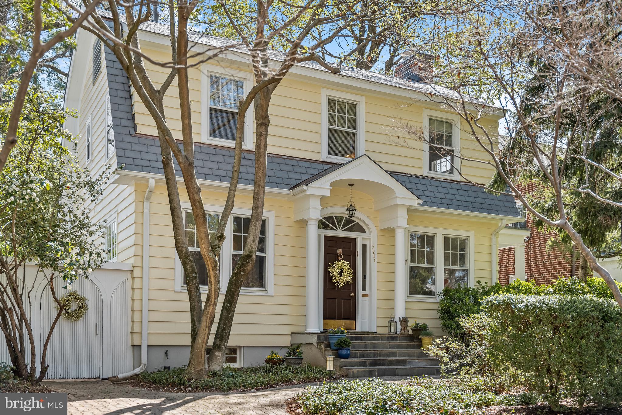 7211 Summit Avenue, a charming 1926 Dutch Colonial on a bucolic street in Martin's Additions, offers comfort, tradition and character.  It is beautifully landscaped on the outside and meticulously maintained on the inside with millwork and architectural details that add the right amount of elegance.  From the intricately detailed banister to the large, marble fireplace in the living room, the finishes are remarkable and reflect a bygone era of superior craftsmanship. The main level has a traditional floor plan but the spacious, family-room addition, directly off the kitchen, creates the space for how we like to live today.  The table-space kitchen has built-in seating and a handsome, lighted cabinet for glassware adding to the warmth and ambiance.  The living room and family room provide direct access to the large deck, ideal for entertaining on a large or small scale.  The Dutch door in the living room opens to the cozy porch beyond.   
The upper level has a lovely, serene primary bedroom suite with three exposures and an en-suite bathroom.  There are three additional bright and cheery bedrooms and an updated, large hall bathroom.  Need a home office?  No problem, there is a separate home office with built-in shelving and desk and a picturesque view of Summit Avenue.  The lower level is finished with a recreation room, ideal for a play area, a game room, an art studio or movie nights.  There is also a full bath and plenty of very clever storage.  This level also has a separate entrance and an enclosed storage room perfect for bicycles, tricycles and scooters.  The exterior has been carefully designed over the years with mature landscaping, full-canopied trees and a wonderful, large dining/entertaining deck with easy access to the family room, kitchen and living room.  Additional storage is available for garden equipment.  The location is ideal and idyllic.  Summit Avenue is a quiet, tree-lined street in Martin’s Additions - a warm, welcoming neighborhood with a strong sense of community.  Just a short stroll away are the Brookville Market, a pharmacy, a dry cleaners and a coffee shop.  La Ferme restaurant is also nearby, and the weekend farm market is a fun place to shop and gather with neighbors.  The Ride On bus to Metro is close by, as are Rock Creek Park and kid-friendly playgrounds.  Open Saturday, May 3, 1 to 3 pm.  Open Sunday, May 4, 2 to 4 pm.
