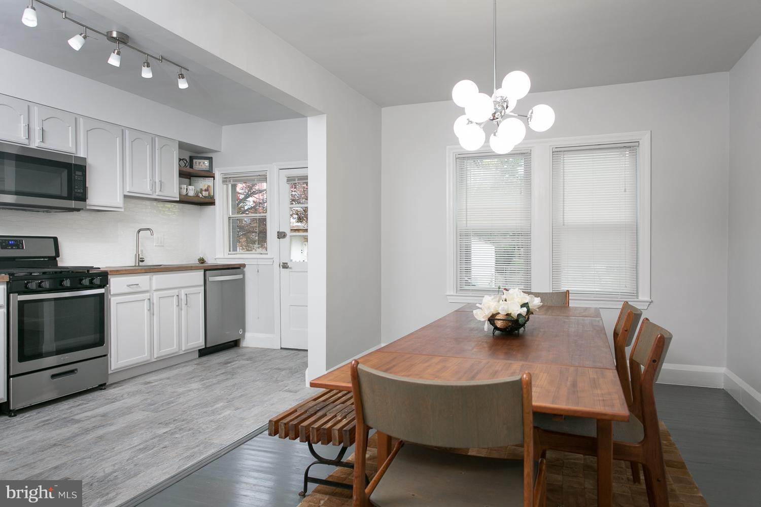 Affordable luxury awaits you in this stunningly renovated home featuring hardwood floors throughout, kitchen open to dining w/ new ss apls, leading to covered back porch. 3 fin lvls w bath on every floor. New, large windows bathe this house in natural light and save energy alongside the new HVAC. Finished lower level complete w/bath perfect for huge, private suite or entertaining.Parking in rear.