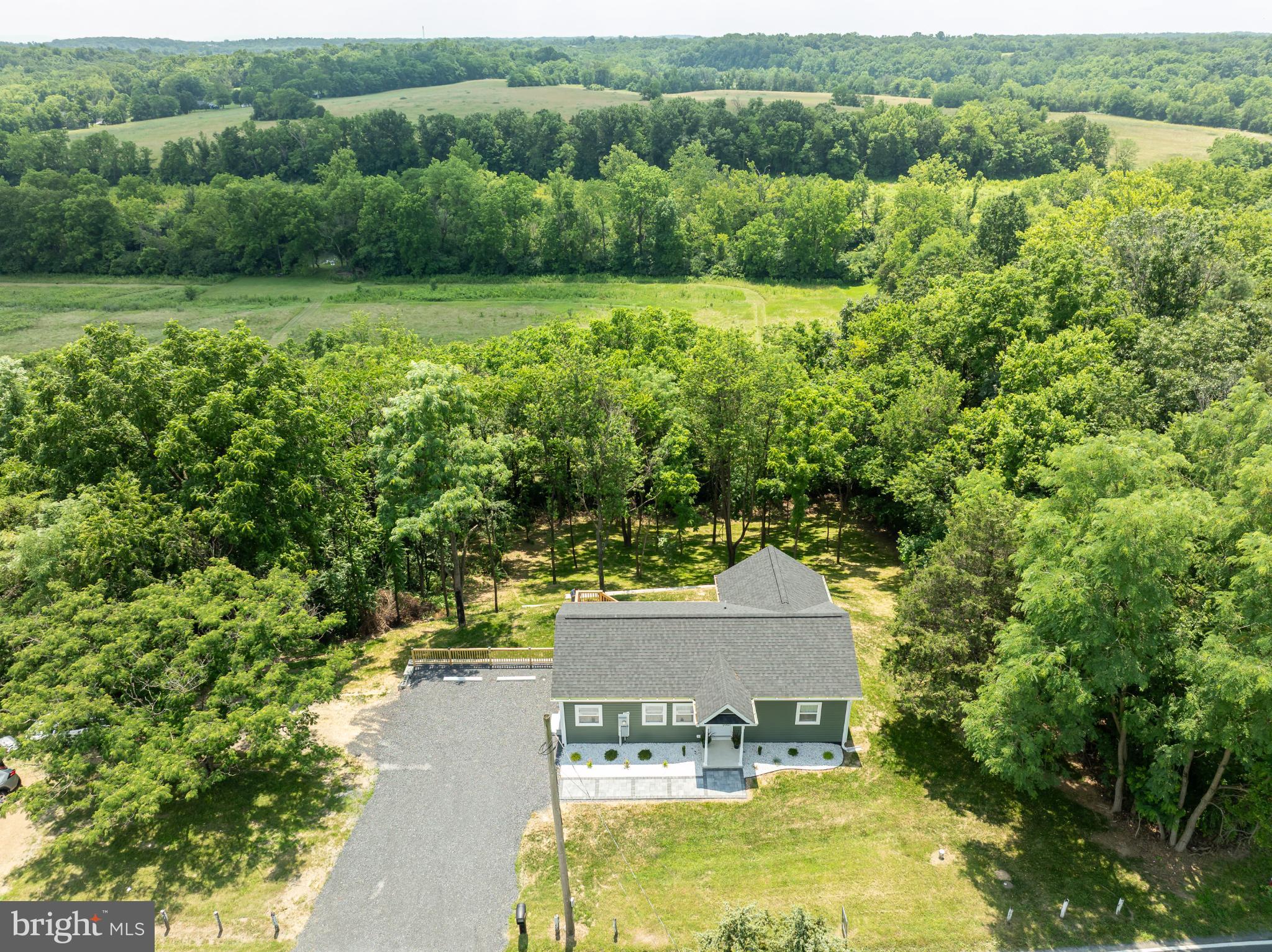 Move in ready! Discover the charm of this delightful ranch-style home, nestled in a serene rural setting. Built in 1991 and set to undergo a major renovation in 2025, this residence offers a perfect blend of comfort and potential. With 2 spacious bedrooms and 2 full bathrooms, the open floor plan invites you to enjoy seamless living and entertaining. The combination kitchen and dining area is perfect for gatherings, while the country-style kitchen features modern appliances, including a dishwasher, refrigerator, stove, and built-in microwave. Natural light floods the home through double-pane windows, enhancing the warm ambiance. Enjoy the convenience of main-floor laundry and a cozy entry-level bedroom. Step outside to your expansive 0.39-acre lot, where you can unwind on the deck, surrounded by trees and open common areas, providing a peaceful retreat. The partly wooded yard offers a perfect backdrop for outdoor activities or simply enjoying nature. Located just 1 to 5 miles from a commuter rail station, this home balances rural tranquility with easy access to transportation. The gravel driveway provides ample parking, while the sloping terrain adds character to the landscape. Embrace the opportunity to make this inviting space your own, where comfort meets potential in a picturesque setting.