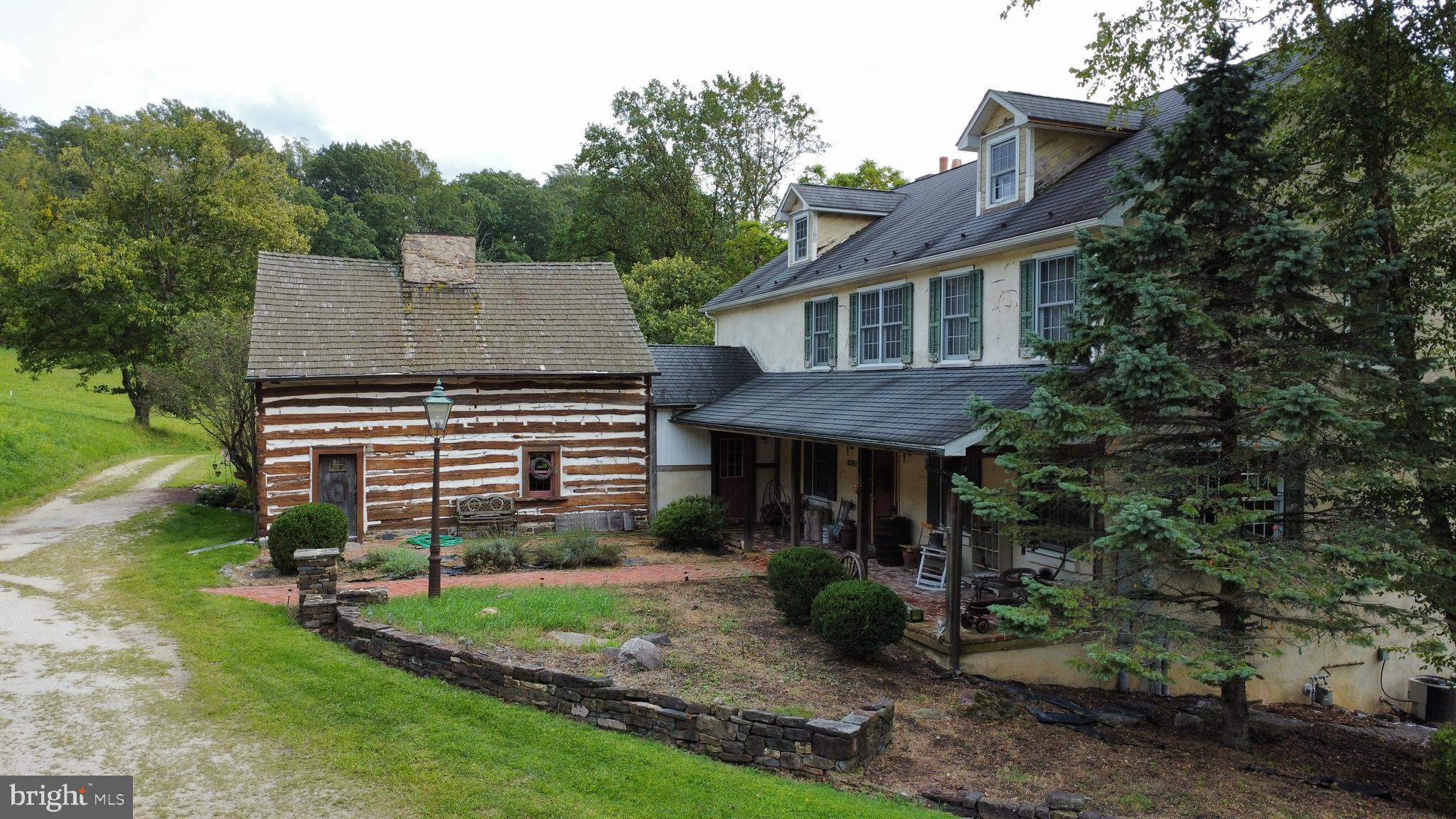 One of a kind opportunity. Situated in both Lower Saucon Township and Springfield Township this 12.21-acre property when purchased by previous owner consisted of a 1700's log cabin with a 24x41 story bank barn and various outbuildings. The visionary owner maintained the log cabin as an accessory dwelling unit and added a 3700 square foot home using materials designed to maintain a rustic 1800's feel. Also added were a two-story detached three car garage, a 31x28 two story bank barn with hay loft and a coy pond. The end result is a stunning property with a large main home and the attached log cabin making a perfect set up for extended family, caretaker quarters or even rental income. The original barn has 4 horse stalls, and the open pastures and fenced pasture make this a perfect property for horses. The main home is modern construction but incorporated materials such as real log beams, reclaimed trim and doors, random width style hardwood floors, stone and brick. The 1st floor features a well-planned open floor plan including a first-floor study or bedroom with full bath nearby. The second floor consists of 4 bedrooms including the primary suite that boasts a gas fireplace, outdoor deck, and an opulent primary bath with whirlpool and steam shower. A 2nd floor den leads to the walk up third floor. The focal points of the daylight walk out basement are the Rathskeller stone wet bar, unique wine cellar and brick fireplace. Bring your finishing touches to this special property.