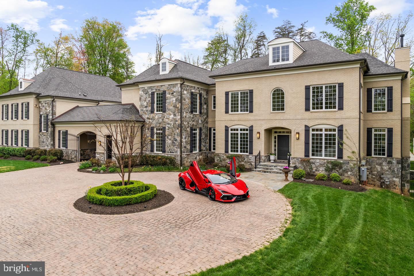 Gracefully positioned at the end of a private cul-de-sac on 2.12 manicured acres, this exceptional French Country estate with a private guest house and resort-style pool offers timeless elegance along the coveted Great Falls–McLean border within the Langley High School pyramid. Built by Keswick Homes, the residence spans 13,448 square feet and showcases soaring ceilings, Brazilian cherry hardwood floors, exquisite millwork, expansive windows, and a three-level elevator. A long private drive leads to a motor court and porte-cochère, setting the tone for the home’s impressive scale and craftsmanship. The chef’s kitchen is beautifully appointed with Sub-Zero, Wolf, and Miele appliances, dual islands, custom cabinetry, and seamless flow to the breakfast room and grand great room with a fireplace. Formal living and dining rooms and light-filled gathering spaces create the perfect balance of luxury and livability. The upper-level primary suite offers a private sitting room, fireplace, balcony, dual custom walk-in closets, and a spa-inspired bath. Of the seven total en suite bedrooms, five are found on this second level.  One primary-size suite, an independent wing of three generously proportioned bedrooms, one with a zero-entry shower with bench seating, extra-wide doorways, and wide hallway access to the elevator, ideal for multigenerational living. The expansive lower level features a media room, wet bar, billiards, recreation spaces, flex rooms, and guest accommodations. Outdoor living is truly spectacular with a 20x40 heated saltwater pool, retractable cover, outdoor kitchen with Viking appliances, stone fireplace pavilion, and over 6,000 square feet of Pennsylvania bluestone patios and covered porches. A detached 3,000+ square-foot carriage house includes its own kitchen, family room, two bedrooms, and a commercial-grade gym, creating an ideal guest residence, wellness retreat, or multigenerational living environment. Moments from Tysons, McLean, and Washington, this extraordinary estate offers privacy, scale, and resort-style luxury in one of the region’s most prestigious settings.