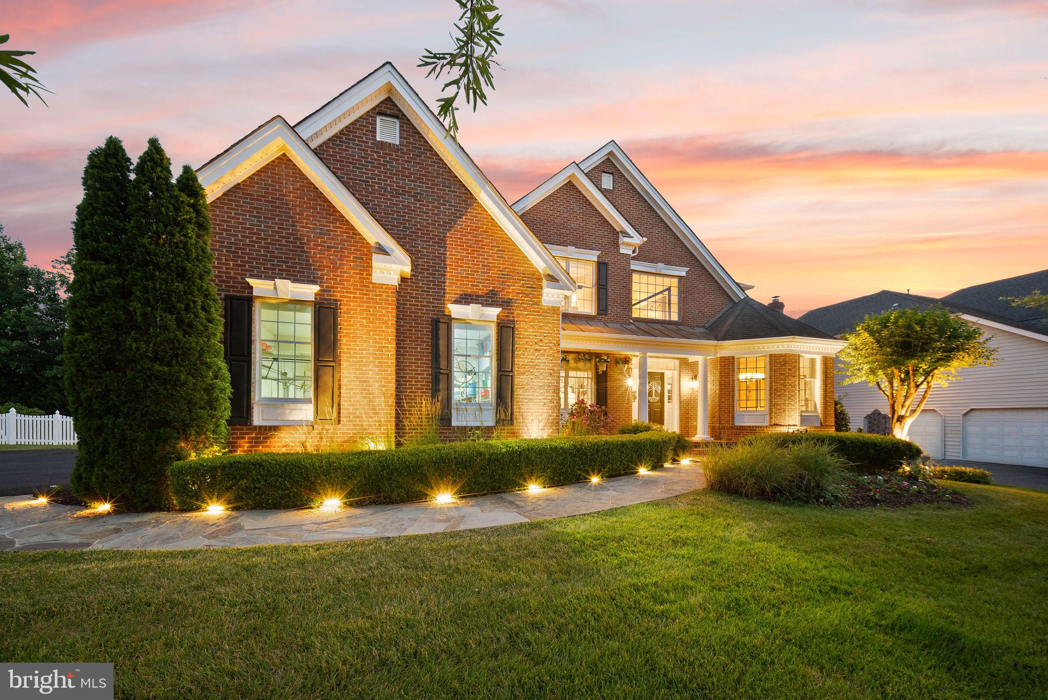 Exceptional brick-front Toll Brothers estate home in the gated community of Belmont Country Club. Beautifully situated on a .31-acre lot, this Elkton Extended model offers generous living spaces, timeless architectural detail, a 3-car side-entry garage, and a finished lower level with walk-up stairs. Thoughtfully updated and enhanced throughout, the home features Brazilian hardwood floors, extensive custom molding, upgraded lighting, elegant ceiling details, and wonderful wall space for artwork.

The main level offers a gracious foyer, formal living and dining rooms, a private library, and a stunning family room with architectural ceiling detail, abundant natural light, and a wood-burning fireplace. The front sitting room is especially memorable with its octagonal ceiling, and the dining and living spaces showcase beautiful trim work and ceiling detail that add warmth and character. The gourmet kitchen is designed for everyday living and entertaining, with high-end Wolf appliances, a custom range hood, a large island with treated marble, and a beautiful porcelain onyx backsplash with custom-painted outlet covers for a seamless designer finish. The kitchen opens to the family room, creating an inviting flow for gatherings large and small. A beautifully finished powder room with linen-look wallcovering, a classic vanity, custom mirror, sconces, and chandelier adds another thoughtful designer touch.

The upper level offers four spacious bedrooms, including a luxurious primary suite with a separate dressing area, custom closet systems, and a beautifully renovated bath with heated floors. The finished lower level adds incredible flexibility with a large recreation/game room, wet bar, 5th bedroom, 4th full bath, and walk-up stairs to the rear yard, creating wonderful space for guests, extended stays, entertaining, or everyday living.

Outdoor living is just as special with an expansive deck, flagstone patio, firepit area, and gazebo, creating multiple places to relax, entertain, and enjoy the private setting.

Belmont Country Club isn’t just a community, it’s a lifestyle.  Residents of Belmont Country Club enjoy exceptional amenities including Arnold Palmer Signature golf course, modern fitness center with classes, 7 tennis courts, and pickleball, three swimming pools, upscale dining at Lee's Table & Tavern, and year-round social events and community activities. The HOA also provides lawn care, trash and recycling, high-speed internet, and cable TV, making homeownership easy and low maintenance. Prime Loudoun County location convenient access to: Washington Dulles International Airport, Belmont Chase shopping, and dining. One Loudoun lifestyle center and Lansdowne Town Center. With nearby access to the Silver Line Metro and major commuter routes, this location blends luxury living with everyday convenience. A rare opportunity to own a beautifully updated home in one of Ashburn’s most sought-after communities.