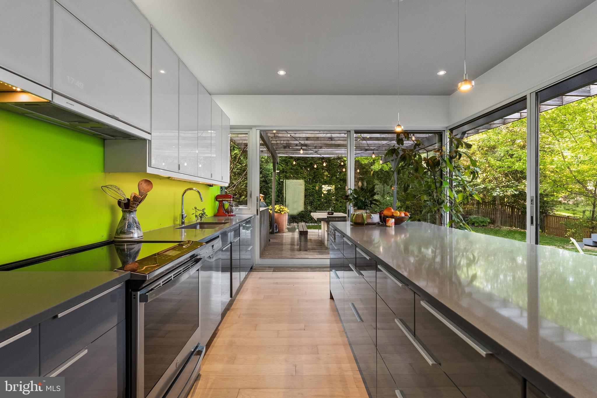 Welcome to Casa Abierta, or "Open House" in Spanish. A home that feels less like a nickname and more like the architectural thesis of the home itself: walls of glass, soaring vaulted ceilings, warm hardwoods, and huge sliding doors. This is a house that feels open, airy, and alive from the moment you walk in. 
Reimagined by award-winning KUBE Architecture, this modern rambler is all about light, volume, and the effortless connection between indoors and out. This is not “modern” in the cold, untouchable sense. It is relaxed modern. Barefoot modern. Coffee on the deck while the doors stay open all morning modern.
This Chevy Chase open-concept layout unfolds beautifully, with floor-to-ceiling windows pulling natural light into nearly every corner of the home. The dramatic living room flows seamlessly into expansive gathering spaces designed for actual living -- dinner parties that drift outside, kids running freely between the courtyard-style spaces, quiet nights around the fire pit, and weekends where nobody wants to leave.
The cathedral ceiling creates a lofted airy space in the family room, with ipe and bamboo flooring to create a warm, grounded base with functionality defined by light and windows. 
At the center of it all is the stunning chef’s kitchen, wrapped in glass and overlooking a lush backyard oasis. A massive center island, sleek stainless steel appliances, and direct access to the wraparound deck create the kind of indoor/outdoor setup buyers chase but rarely find done this well. The deck itself feels like an extension of the house, complete with built-in seating, flower boxes, and private green views in every direction.
The main level also offers three sun-filled bedrooms, including a dreamy primary suite with sliding glass doors opening directly to the backyard -- equal parts boutique hotel and private retreat. Fully flexible in design, the suite features a modern en suite bath and custom walk-in closet for organization.
The fully-finished lower level adds flexibility with a stylish recreation room, updated full bath, mudroom, laundry, garage access, and exceptional storage. Energy savings from day one with solar panels by Solar Solutions that are fully owned out right with two solar backup batteries, as well as a dedicated EV charger. SRECs are passed to the buyer.
Rollingwood is the quiet, cool pocket of Chevy Chase -- tucked against Rock Creek Park, moments to trails, tennis courts, Candy Cane City, Meadowbrook Stables, Brookville Market, La Ferme, and the Saturday farmers market. B-CC schools serve the neighborhood.
Even among Rollingwood’s charming homes, this one stands apart. It is design-forward without trying too hard. Warm without sacrificing edge. A house that genuinely understands how people want to live now.