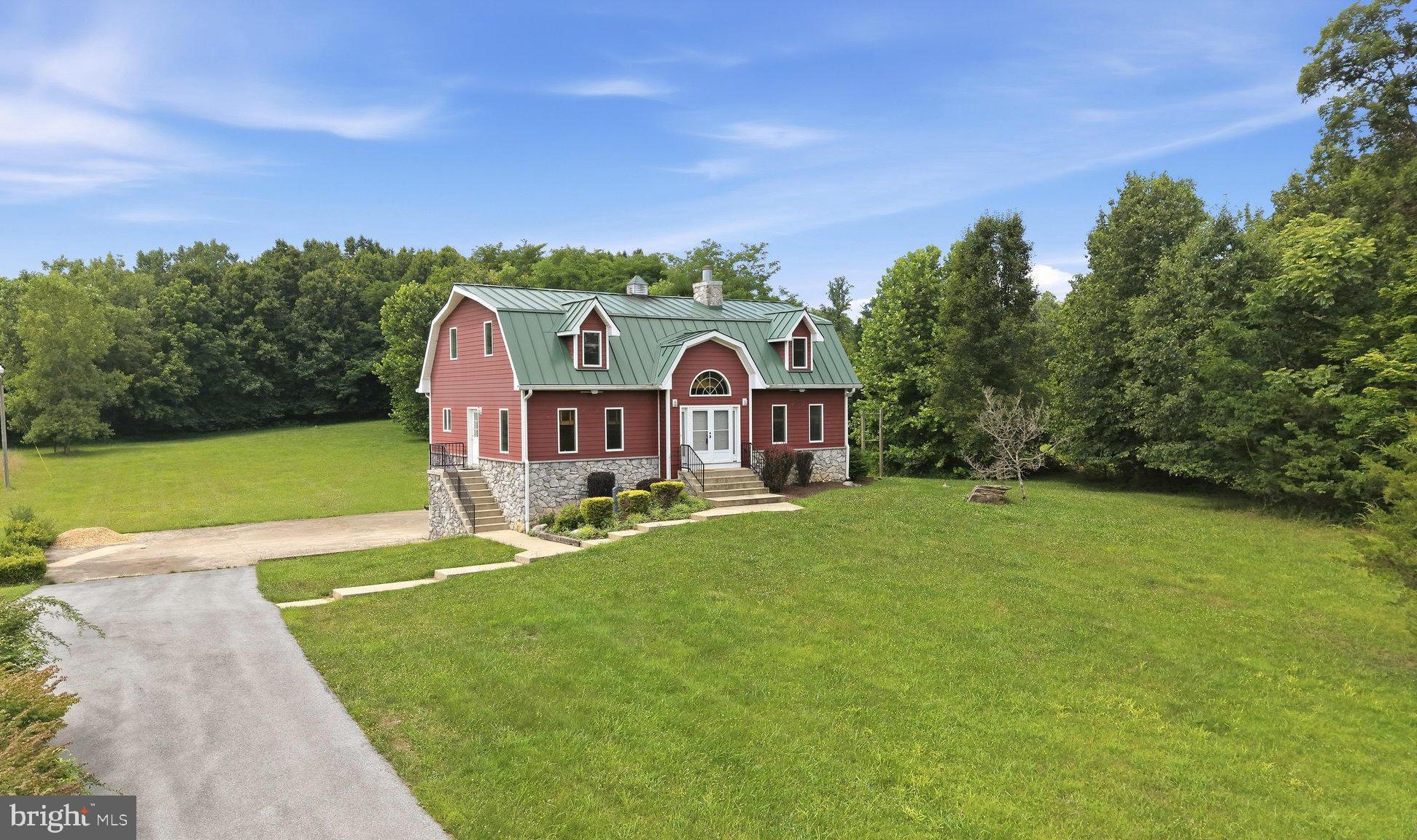 Set on a  5-acre unrestricted lot right across from the Potomac River, this one-of-a-kind custom home with in-ground pool and seasonal river views blends timeless character with spacious, functional living space. Exposed wood beams, rich hardwood floors, and two stunning  floor-to-ceiling stone fireplaces create warmth and architectural charm throughout the more than 4,200 finished square feet. The thoughtfully designed floor plan offers five bedrooms on three levels, including a main-level owner's suite, plus two additional upstairs flex rooms ideal for a home office, hobby space, fitness room, or guest accommodations. The kitchen is designed for functionality, featuring a center island, butler's pantry, abundant cabinetry, and seamless flow into the light-filled dining room. The finished lower level expands the living space, offering the perfect gathering place for movie nights, recreation, or guest space. Whether you're relaxing poolside or entertaining family and friends, this property offers the perfect balance of comfort, recreation, and serenity in a great Berkeley County location within minutes of the Yankauer Nature Preserve, Whitings Neck Equestrian Center, and Izaac Walton League offering river access, walking trails, and more. With distinctive craftsmanship throughout, this exceptional property is a rare opportunity for peaceful living with proximity to many conveniences , commuter routes, and seasonal activities.