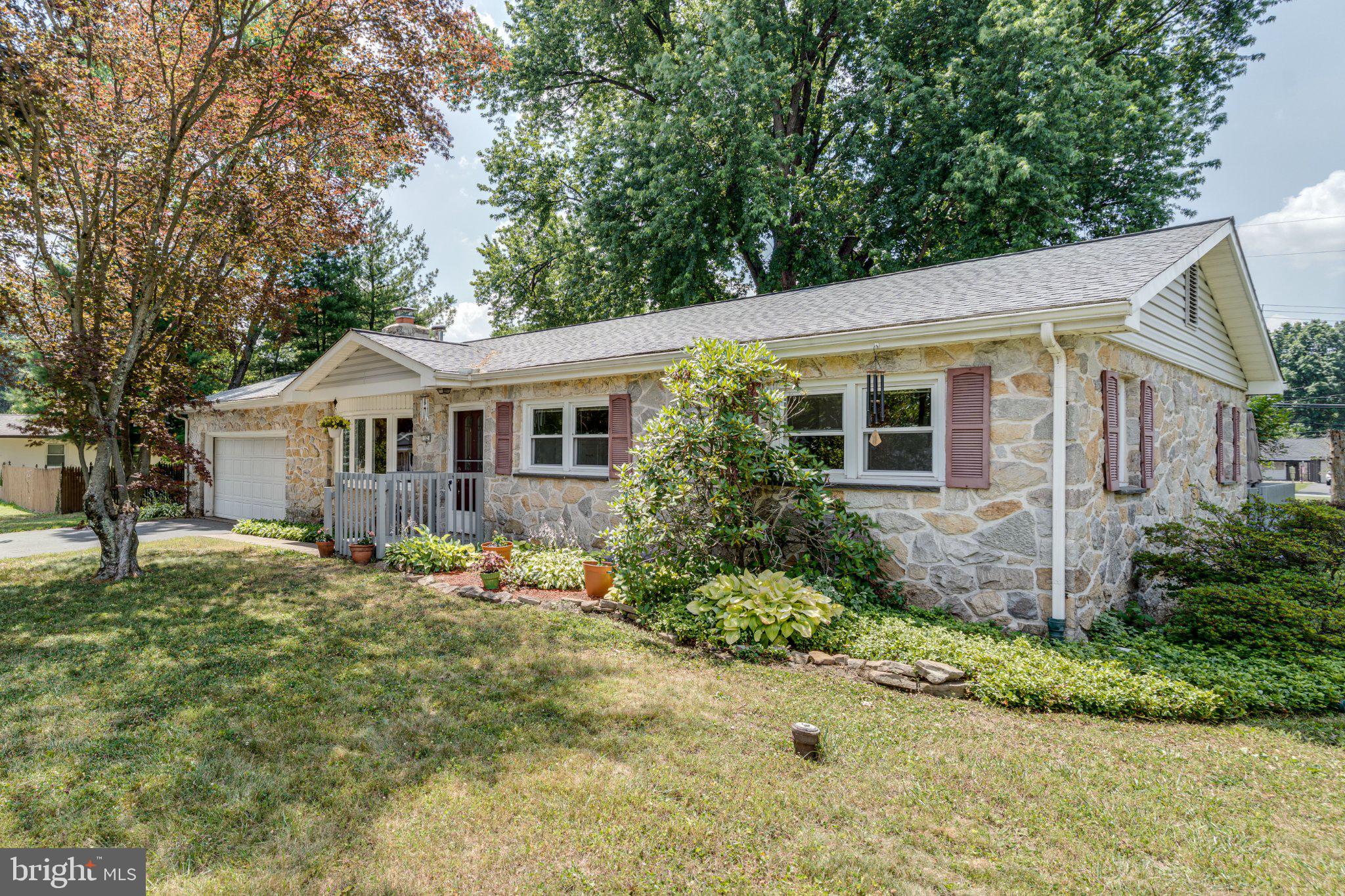 Welcome to 12 Heather Lane, where timeless stone construction meets thoughtful updates. This well-maintained ranch home offers the convenience of one-floor living while providing the space and features today's buyers appreciate. Inside, you'll find three bedrooms, including a spacious primary suite with a beautifully renovated private bath featuring a walk-in shower. The updated hall bath offers dual vanities and a tub/shower combination. Hardwood flooring extends through much of the home, while the living room serves as a warm and inviting gathering space with a stone-faced wood-burning fireplace and a large bay window that fills the room with natural light. The updated kitchen provides generous cabinet storage and opens to a sizable four-season room highlighted by charming atrium windows and French doors leading to the rear deck, creating an ideal space to enjoy the changing seasons or expand your everyday living area. The full unfinished basement offers excellent potential for future finishing or storage and includes a French drain system, dual sump pumps, and Bilco doors for exterior access. Additional improvements and features include: New roof (2025), reverse osmosis drinking water system, HVAC system approximately 10 years old with servicing completed within the past year, active radon mitigation system, well water testing completed within the last year, two-car attached garage with interior access and rear service door. Situated on nearly one-half acre, the level lot is enhanced by mature trees and established landscaping, offering both beauty and functionality. A hydraulic wheelchair lift is currently installed and may be included with the sale. If you're searching for the character of a classic stone ranch combined with meaningful updates and room to make it your own, 12 Heather Lane is ready to welcome you home. Notice to buyer: Some images have been virtually staged.