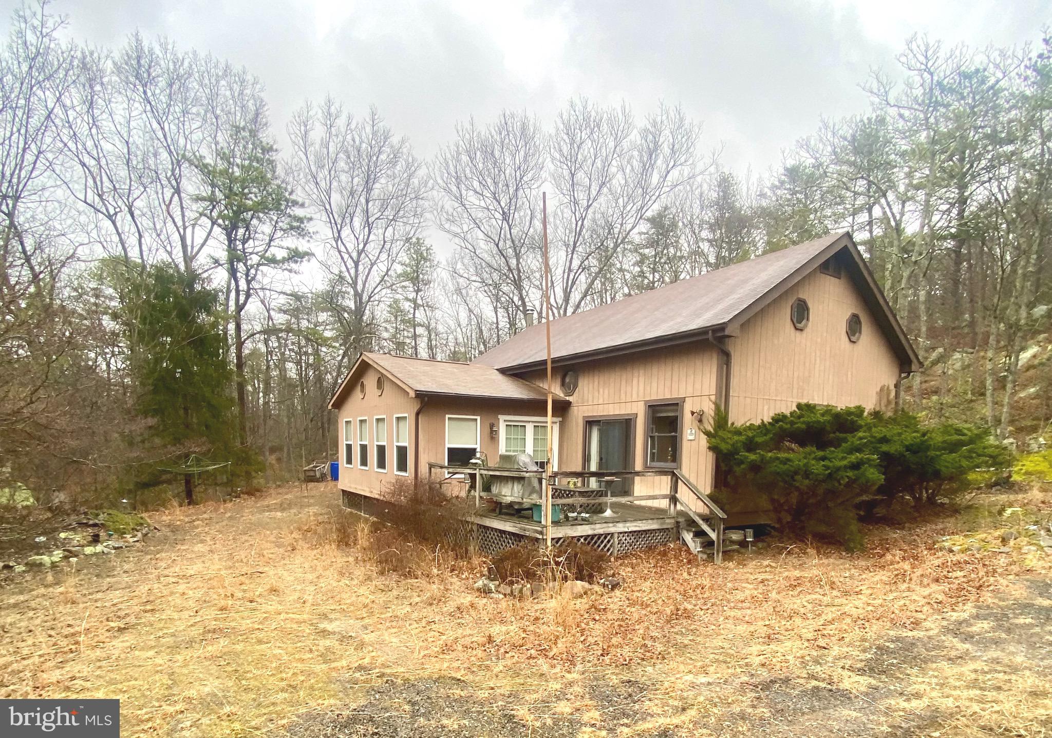 This is your chance to own your own cabin in wild, wonderful West Virginia!!!  This home is secluded and private but close to all the amenities the community offers.  Inside you will find a modern kitchen with an island, a huge family room, and a dining area.  There is also a large sun room with lots of windows, and a main floor bedroom and full bath.  Outside there is a deck perfect for a hot tub,  two large outbuildings, and a flat yard.  There is also an over-sized garage/workshop! The community offers a stocked fishing lake, a beautiful swimming lake with sand, tennis courts, a park for the kids and 18 plus miles of roads to ride your ATV.  This house would work as a full time residence, a weekend get away or an Airbnb.  Don't miss this one!
