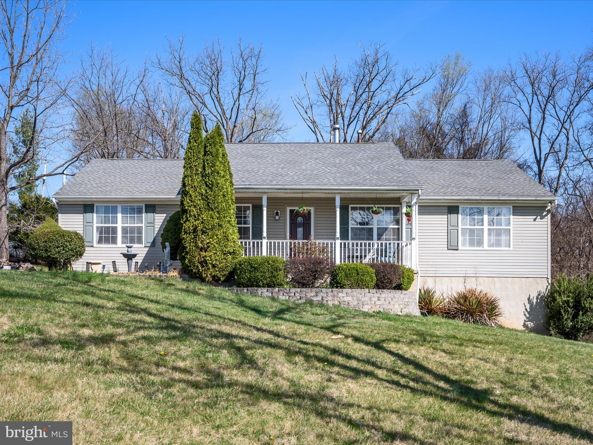 This lovely Clarke County home sits on a knoll with nearly four pristine acres facing the Blue Ridge Mountains. Enjoy the view with a morning cup of coffee from the front porch.  This house is deceptive because it appears to be a ranch at first glance, but there are actually two finished floors.  Enter the front door into a large living room. There are two bedrooms, each with their own ensuite on opposite sides of the living room.  The lower level of the home is finished and includes two additional bedrooms with full-size windows, another full bath, and a rec room spanning the entire length of the house. A sliding glass door opens at ground level to a side yard. Find the deck located just off the kitchen, perfect for hosting a summer barbecue.