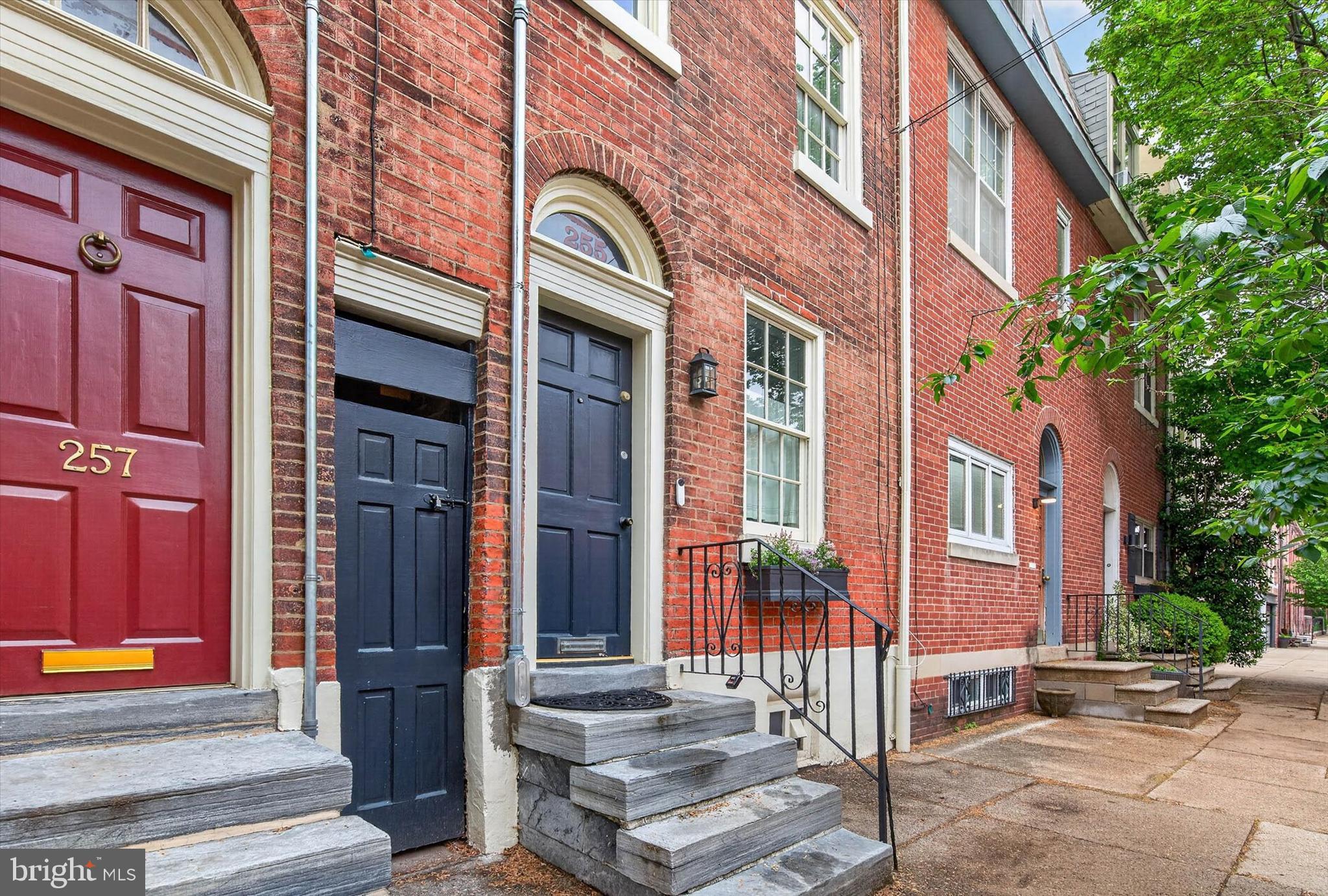 Welcome to 255 Queen Street, a gem from 1806 nestled in the heart of Philadelphia's vibrant Queen Village neighborhood on one of the most desirable blocks between 2nd & 3rd. This three-story townhome is a blend of classic charm and modern comfort, offering a unique living experience that's hard to resist. As you approach the property, you are greeted by the original front limestone steps and an elegant arched doorway, inviting you into a home filled with natural light and stylish city living on all three levels. The beautiful hardwood flooring throughout the house adds a touch of warmth and elegance. The updated kitchen is a chef's dream, equipped with sleek granite countertops, new stainless appliances, a convenient island, and a window perched above the sink, allowing for a flood of natural light. The built-in pantry and coat closet provide ample storage, while the radiant heated floors ensure comfort during the colder months. The living room, graced with high ceilings, is perfect for both entertaining and relaxation. A sliding door opens to a private rear patio, featuring a contemporary style horizontal plank fence. Here, you can relax and dine al-fresco, enjoying the tranquility of your own private outdoor space. The second-floor houses two bedrooms and a full bath, while the third floor suite offers the main bedroom, a studio/office area, and an additional full bath. Each level of the home offers newly added central ac, a unique living experience, catering to a variety of needs and preferences. But the appeal of this property extends beyond its walls. Located on a tree-lined street just steps away from Mario Lanza Park, this home is situated in a welcoming neighborhood bursting with eclectic restaurants, trendy shopping, art galleries, vintage boutiques and the nearby farmers market at Headhouse. Plus, the Delaware River Waterfront is easily accessible, offering a host of recreational activities. Experience the best of city living at 255 Queen Street, where history, modernity, and community come together in perfect harmony, with the added bonus of a Top Rated School District! Don't miss the opportunity to make this charming townhome your own. LOOK FOR ADDITIONAL PHOTOS ON 5/6TH.