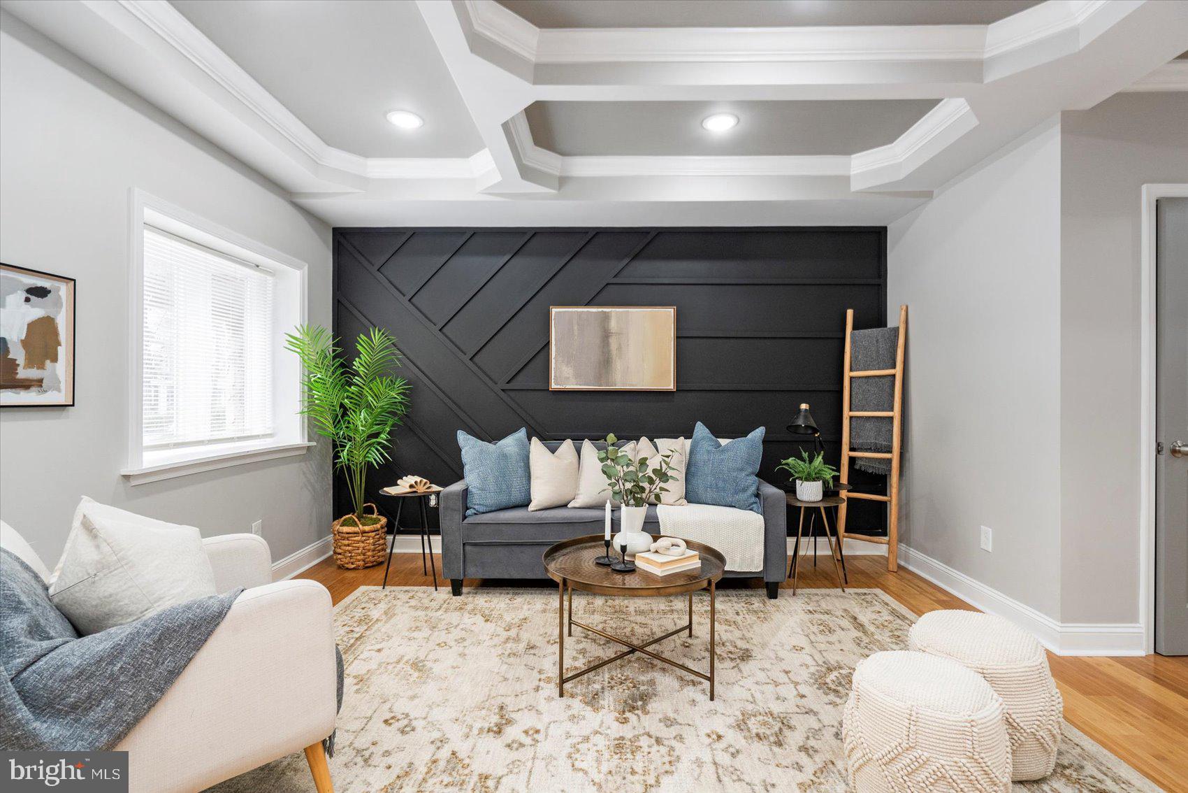 A beautiful transformation has taken place inside this 4BR/3.5BA Townhome located in a desirable neighborhood.  Make your way to the covered front porch of your new home and open the door into an open concept main floor featuring custom coffered ceiling, hardwood floors, recessed lighting, a soft color palette, and tons of natural light.  The spacious living room boasts a custom feature wall and is open to the dining room and stunning kitchen.  The kitchen boasts plenty of cabinets, stainless steel appliances, sleek quartz countertops with a complimenting tiled backsplash, and a stainless sink set into an island with a waterfall edge and breakfast seating for three. Just off the kitchen is a large pantry closet, and a half bath.  On the newly carpeted second floor are two sizable secondary bedrooms, a beautifully tiled full bath, and a large primary suite.  The primary features a private en suite boasting a stunningly tiled walk-in shower and two closets.  The lower level is finished featuring the fourth bedroom, a full bath with another beautifully tiled walk-in shower, a laundry room, storage, a large family room, and a walk-out to Bilco doors in the fenced yard.  From the kitchen step outside to ayard filled with green space and off street parking for two cars. This home is move-in ready with tons of luxury throughout, and is located in close proximity to shopping, restaurants, and commuter routes.