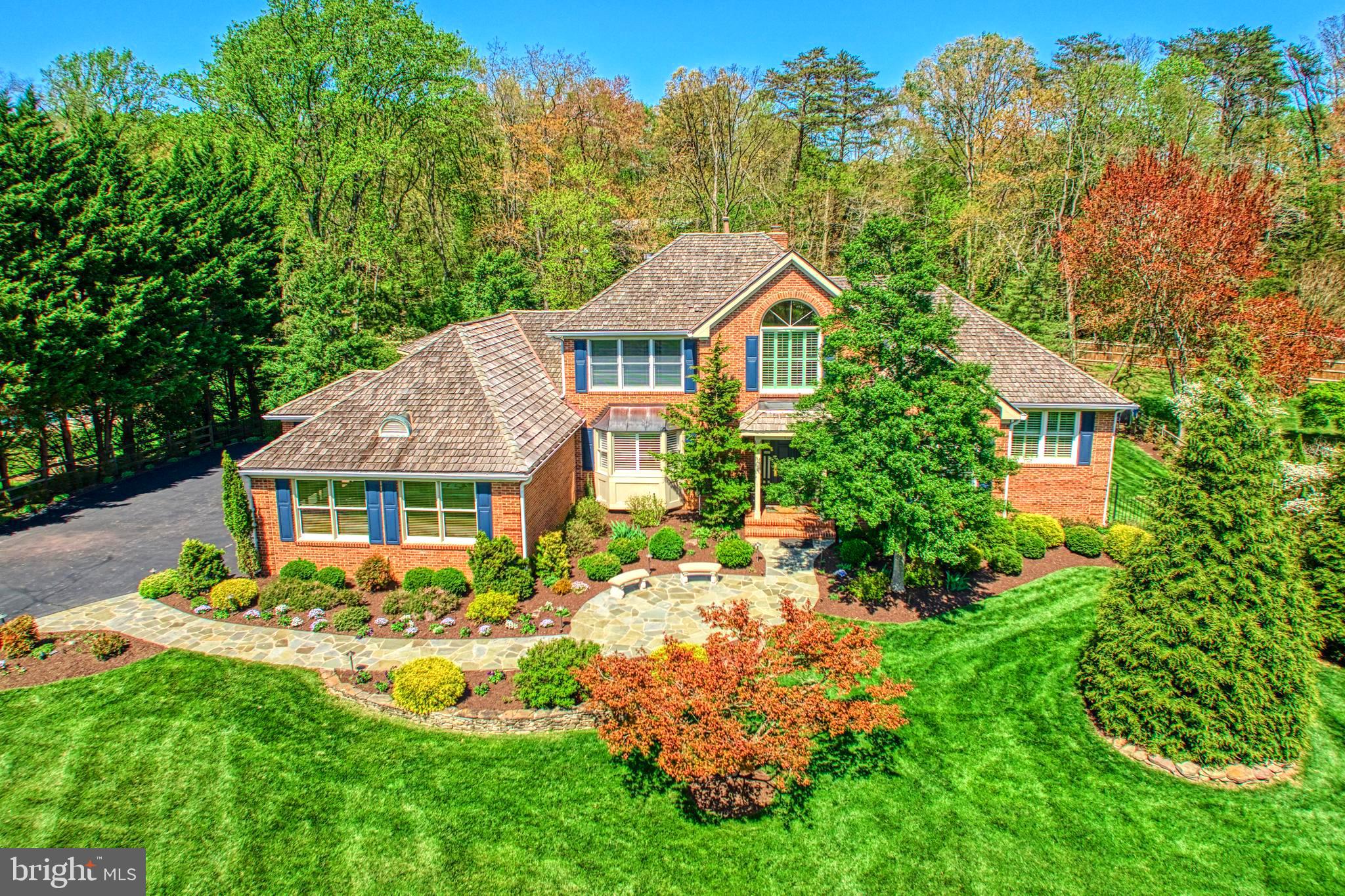 Country Setting - yet so close in!   This luxurious four-sided brick home has it all....a three car side load Garage, a two story Entry Foyer, a main level Primary Suite with it's own Sitting Room and an enormous custom renovated Primary Bath, four Bedrooms and four & one half Baths - over 6,000 sq ft....located on over an acre of land! The updated gourmet Kitchen has been reconfigured with high end appliances, extra cabinetry, marble counters and a convenient Butlers Pantry. In addition to the formal Living and Dining Rooms, there is a main level Office with adjustable built-ins and extra storage, and a double Family Room / Sun Room  -  one with coffered ceilings and the other with wood cathedral ceilings and skylights. These two rooms  are separated and look out on a stately two story gas STONE fireplace.....
The upstairs leads  to three large Bedrooms , two sharing a Jack & Jill Bath and one with its own en-suite. Both Baths have been updated.  
The stunning Lower Level lends itself to all kinds of possibilities.  There is full walkout access with 9 ft ceilings, oversized windows and a third gas fireplace - stone. The Recreation Room is the main focus and is generous and open enough to house both a Sitting Room and a Play Rm - large enough for a pool table. Overlooking this is a fully equipped Wet Bar/Kitchenette with a small fridge and a dishwasher and a recently added Wine Cellar.....perfect for entertaining with room enough for many!
In addition to the Storage Room with built-in shelves, there are three additional rooms that can be used as needed .....perhaps as a 2nd  Office or an Exercise Room with access to the 4th full Bathroom.
This spacious lower level opens out to a breathtaking professionally landscaped rear yard with
a gorgeous custom heated Pool and Spa (resurfaced 2 years ago)........all surrounded by  extensive stone, brick and slate hardscaping & professionally installed custom lighting (both in front & back).
In addition to the Patios , there is a Trex deck off the main Kitchen /Family Room with a built-in cooking station and a custom Veranda overlooking the pool and yard. and a separate wood firepit!
Windows have been replaced, floors have been refinished, Kitchen and Baths have been updated.....Perfect for both the day to day family living and entertaining, this home has been  cared for and exceptionally maintained by the original Owners!   Open Sunday 5/18 1pm to 3pm Watch the videos!